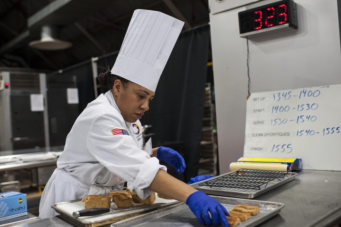 Staff Sgt. Aqueelah James, a U.S. Army Reserve Culinary Team member with the 3rd Medical Command (Deployment Support), Fort Gillem, Ga., cuts her Walnut Cake for her Island Dream Dessert during the Practical and Contemporary Hot Food Cooking/Patisserie category at the 41st Annual Military Culinary Arts Competitive Training Event, March 7, 2016, at Fort Lee, Va. James, who earned a silver medal in the category, used the influences of her family heritage from the islands of Saint Kitts and Nevis and the Dominican Republic as inspiration for the dessert. (U.S. Army photo by Timothy L. Hale/Released)