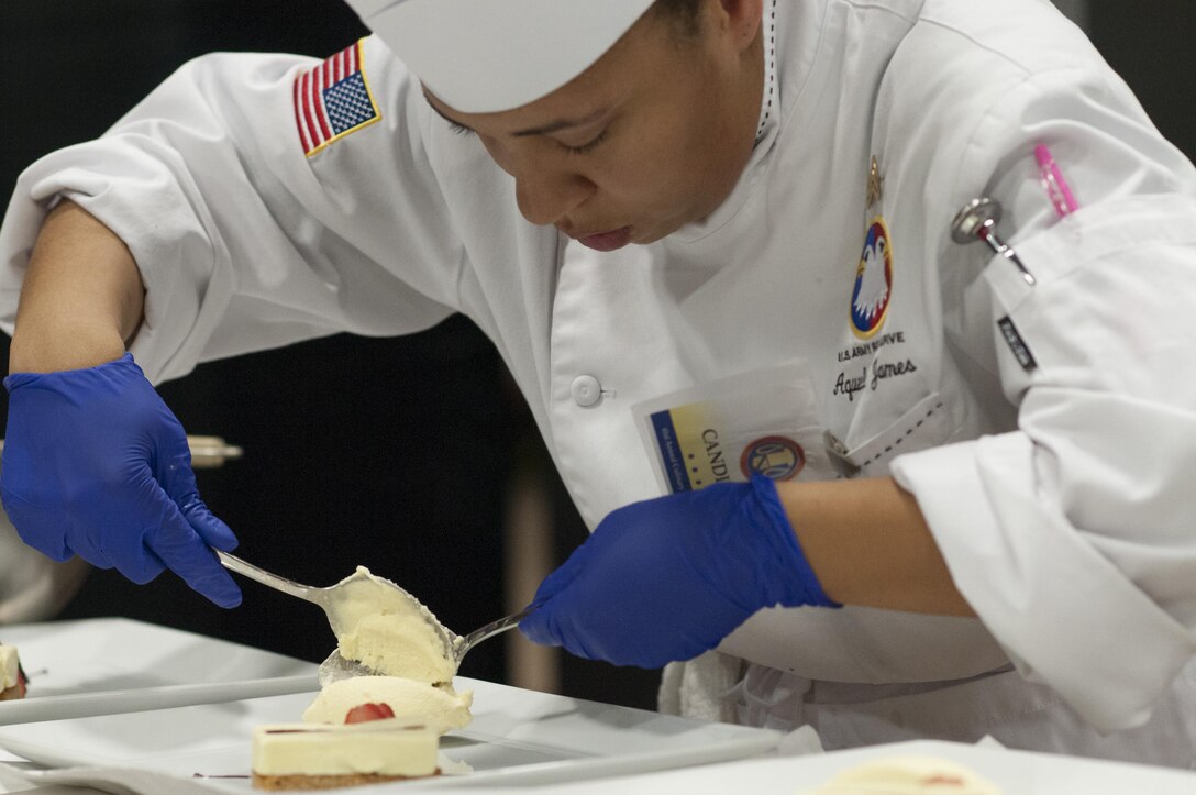 Staff Sgt. Aqueelah James, a U.S. Army Reserve Culinary Team member with the 3rd Medical Command (Deployment Support), Fort Gillem, Ga., puts the finishing touches on her Island Dream Dessert during the Practical and Contemporary Hot Food Cooking/Patisserie category at the 41st Annual Military Culinary Arts Competitive Training Event, March 7, 2016, at Fort Lee, Va. James, who earned a silver medal in the category, used the influences of her family heritage from the islands of Saint Kitts and Nevis and the Dominican Republic as inspiration for the dessert. (U.S. Army photo by Timothy L. Hale/Released)