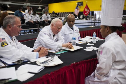 Chef judge Roland Schaeffer critiques the Island Dream Dessert entry of Staff Sgt. Aqueelah James, a U.S. Army Reserve Culinary Team member with the 3rd Medical Command (Deployment Support), Fort Gillem, Ga., in the Practical and Contemporary Hot Food Cooking/Patisserie category at the 41st Annual Military Culinary Arts Competitive Training Event, March 7, 2016, at Fort Lee, Va. James, who earned a silver medal in the category, used the influences of her family heritage from the islands of Saint Kitts and Nevis and the Dominican Republic, as inspiration for the dessert. (U.S. Army photo by Timothy L. Hale/Released)