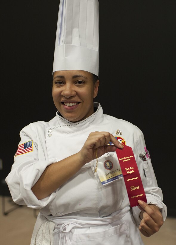 Staff Sgt. Aqueelah James, a U.S. Army Reserve Culinary Team member with the 3rd Medical Command (Deployment Support), Fort Gillem, Ga., is all smiles after scoring a silver for her Island Dream Dessert during the Practical and Contemporary Hot Food Cooking/Patisserie category at the 41st Annual Military Culinary Arts Competitive Training Event, March 7, 2016, at Fort Lee, Va. James used the influences of her family heritage from the islands of Saint Kitts and Nevis and the Dominican Republic as inspiration for the dessert. (U.S. Army photo by Timothy L. Hale/Released)