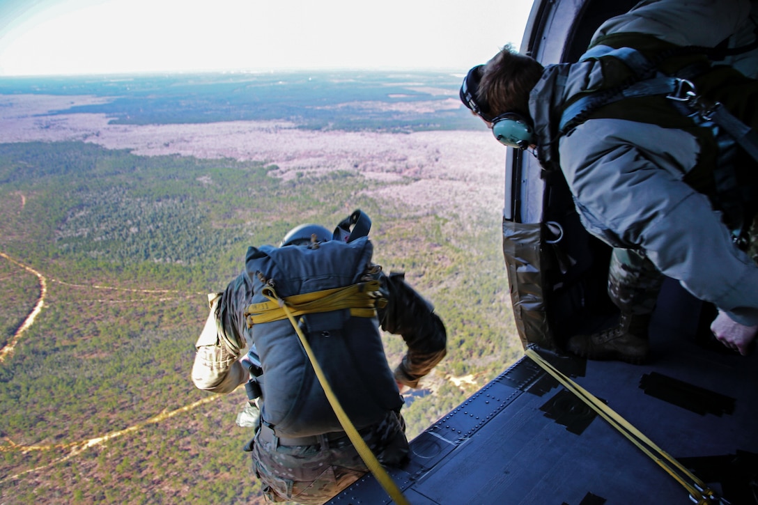 A soldier jumps out of a UH-60 Black Hawk helicopter during an airborne operation over a drop zone on Camp Rudder, Fla., Feb. 25, 2016. Army photo by Sgt. Sara Wakai