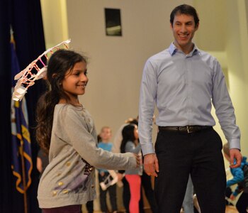 Navy aerospace engineer Eric Silberg  watches as a student from Carderock Spring Elementary School in Bethesda, Md., prepares to test her glider during the Seaplane Challenge at Naval Surface Warfare Center, Carderock Division in West Bethesda, Md.,  Feb. 25. NSWCCD engineers mentored students at the school as they built their planes, and encouraged the students to approach challenges as engineers do. Since 2014, more than 300 students from Maryland and Virginia have participated in the program.(U.S. Navy photo by James Contreras/Released)