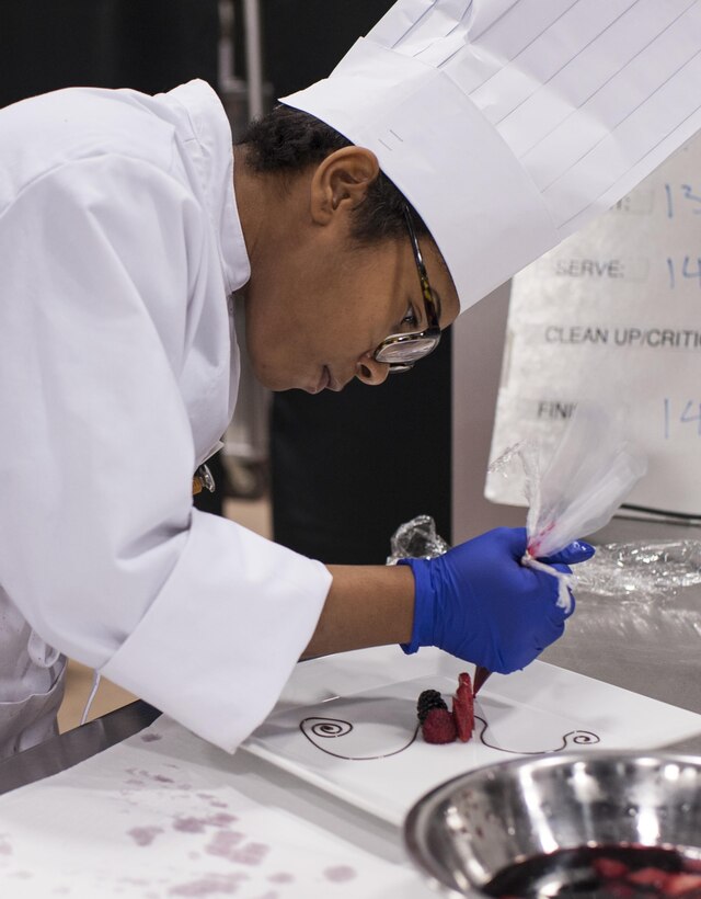 Pfc. Tyquanda Dennis, with the 275th Quartermaster Company, Fort Pickett, Va., puts the finishing touches on her entry during the Armed Forces Junior Chef of the Year competition during the 41st Annual Military Culinary Arts Competitive Training Event at the Joint Culinary Center of Excellence, March 6, 2016, at Fort Lee, Va. Dennis, who has been on the U.S. Army Reserve Culinary Arts Team for only three days, scored a bronze medal in her first competition. (U.S. Army photo by Timothy L. Hale/Released)