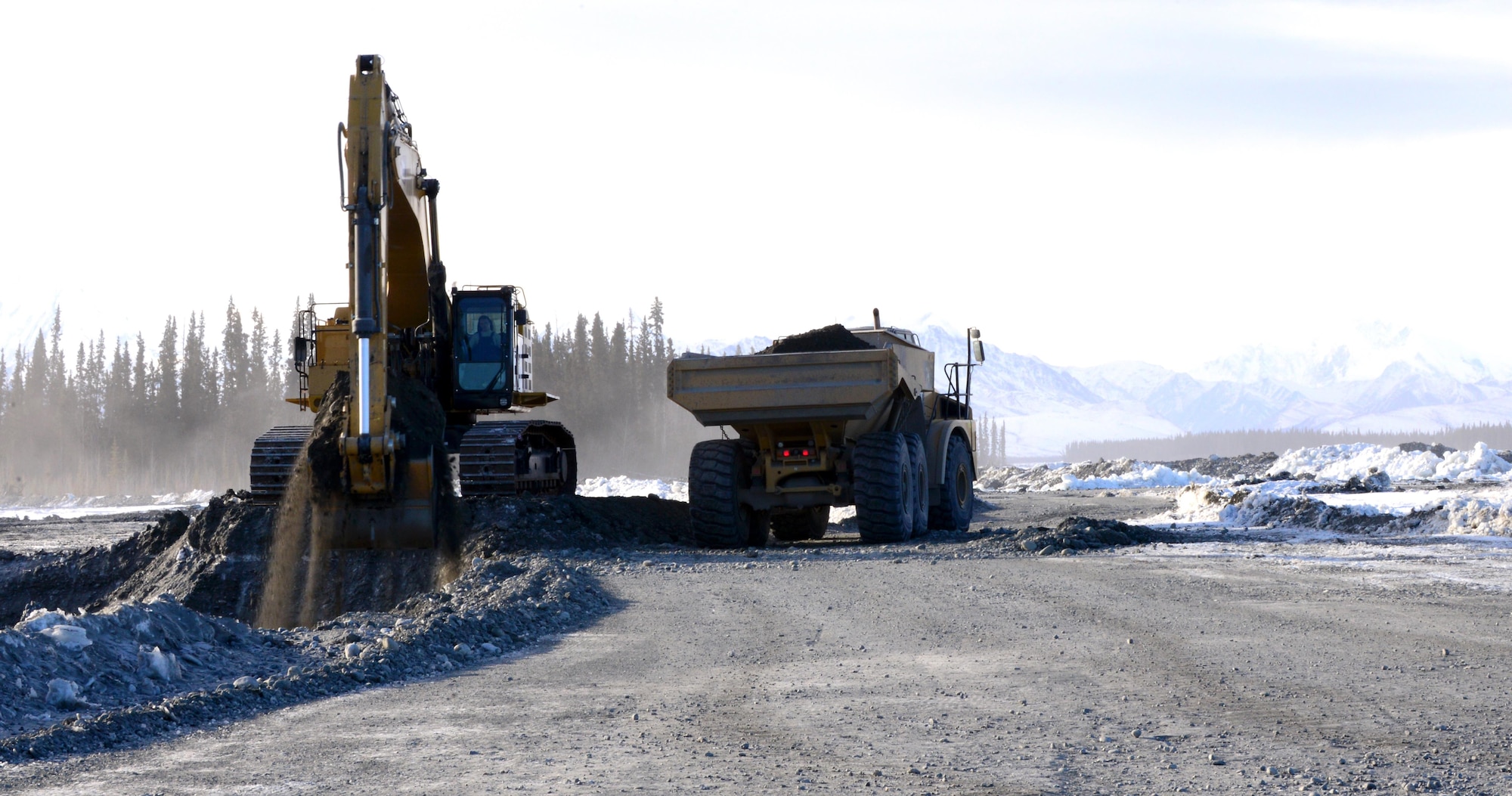 Airmen from the 354th Civil Engineer Squadron operate heavy equipment March 2, 2016, in Delta Junction, Alaska. The Airmen haul truck-loads of dirt to different areas to create a trail system on the Oklahoma Range. (U.S. Air Force photo by Airman 1st Class Cassandra Whitman/Released)