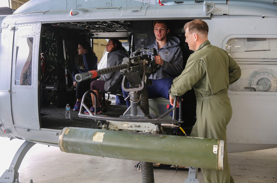 A member of the Notre Dame Lacrosse Team, University of Notre Dame, mans a weapons system on an aircraft at Marine Corps Aircraft Wing, Marine Corps Base Camp Pendleton, Calif., March 7. The students were given the opportunity to board the different aircrafts and see what they looked like on the inside.