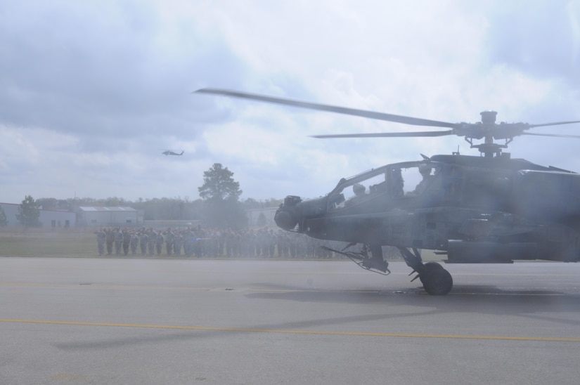 An AH-64 Apache Helicopter, from 1-158th Assault Reconnaissance Battalion (ARB), taxis while soldiers offer their final salute, during a ceremony in Conroe, Texas, to commemorate the final flight of the Apache helicopter in the U.S. Army Reserve, Mar. 6, 2016. 1-158th ARB is a direct reporting unit to the 11th Theater Aviation Command. The 11th Theater Aviation Command (TAC) is the only aviation command in the Army Reserve. (U.S. Army Photo by Capt. Matthew Roman, 11th Theater Aviation Command Public Affairs Officer)