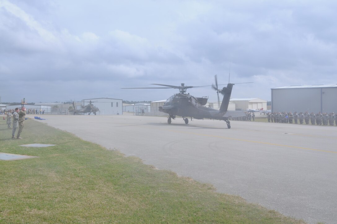 An AH-64 Apache Helicopter, from 1-158th Assault Reconnaissance Battalion (ARB), taxis while soldiers offer their final salute, during a ceremony in Conroe, Texas, to commemorate the final flight of the Apache helicopter in the U.S. Army Reserve, Mar. 6, 2016. 1-158th ARB is a direct reporting unit to the 11th Theater Aviation Command. The 11th Theater Aviation Command (TAC) is the only aviation command in the Army Reserve. (U.S. Army Photo by Capt. Matthew Roman, 11th Theater Aviation Command Public Affairs Officer)