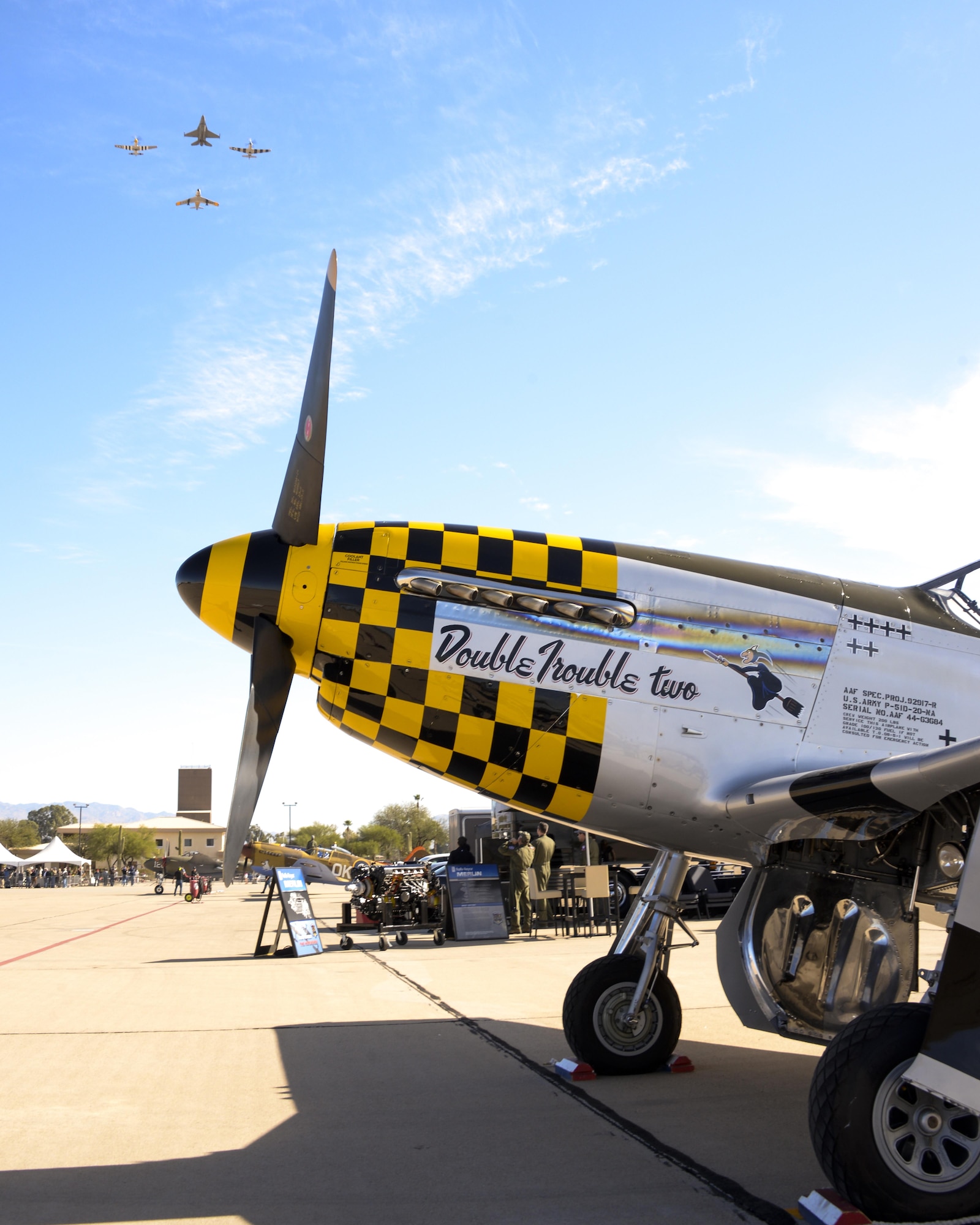 A P-51 Mustang sits on the flightline in the foreground as a U.S. Air Force F-16D Fighting Falcon, two P-51 Mustangs and an F-86 Sabre fly overhead during the 2016 Heritage Flight Training and Certification Course at Davis-Monthan Air Force Base, Ariz., March 4, 2016. Established in 1997, the HFTCC certifies civilian pilots of historic military aircraft and U.S. Air Force pilots to fly in formation together during the upcoming air show season. (U.S. Air Force photo by Senior Airman Chris Massey/Released)