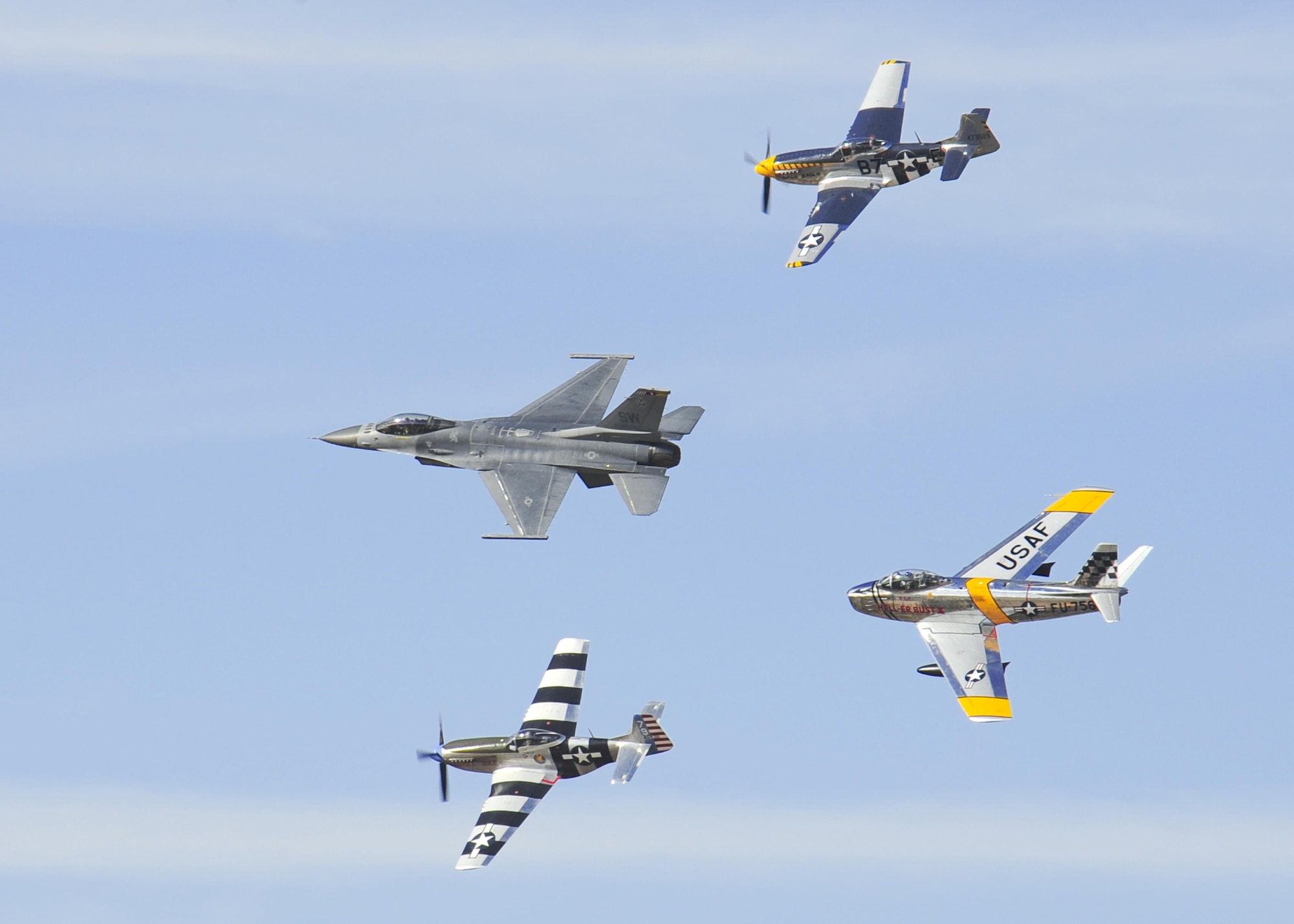 A U.S. Air Force F-16 Fighting Falcon, front, leads a formation followed by two P-51 Mustangs, top and bottom, and an F-86 Sabre, rear, during the 2016 Heritage Flight Training and Certification Course at Davis-Monthan Air Force Base, Ariz., March 4, 2016. Established in 1997, the HFTCC certifies civilian pilots of historic military aircraft and U.S. Air Force pilots to fly in formation together during the upcoming air show season. (U.S. Air Force photo by Senior Airman Chris Massey/Released)