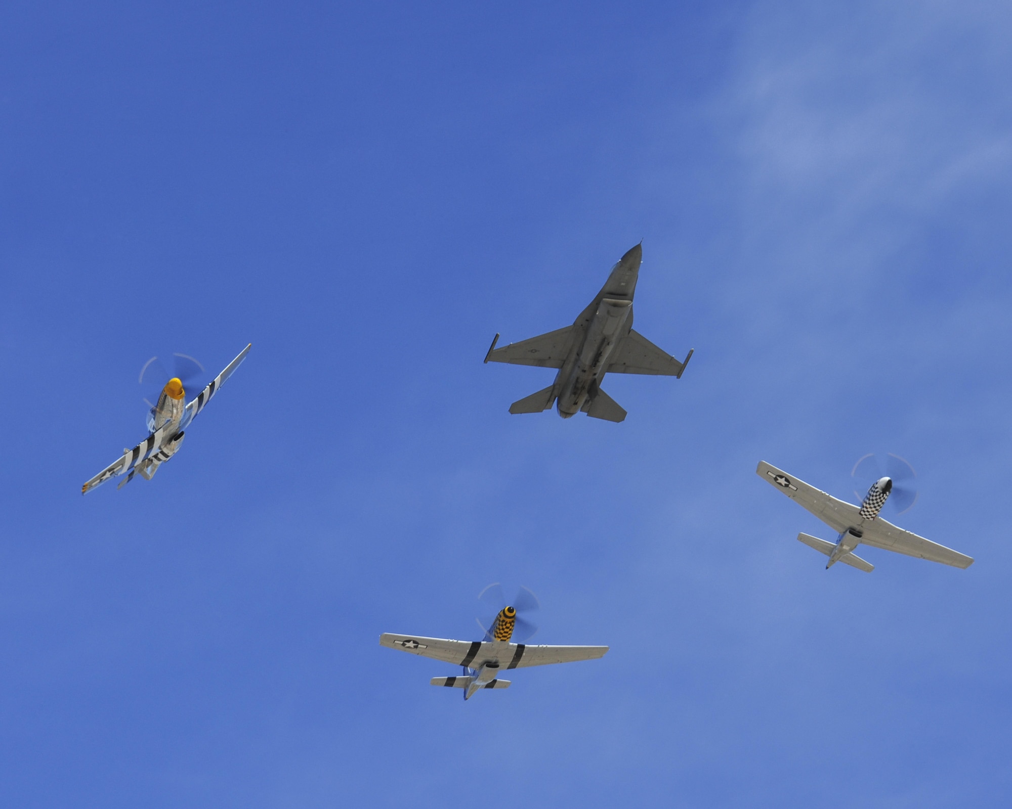 A U.S. Air Force F-16 Fighting Falcon, front, leads a formation followed by three P-51 Mustangs during the 2016 Heritage Flight Training and Certification Course at Davis-Monthan Air Force Base, Ariz., March 4, 2016. Established in 1997, the HFTCC certifies civilian pilots of historic military aircraft and U.S. Air Force pilots to fly in formation together during the upcoming air show season. (U.S. Air Force photo by Senior Airman Chris Massey/Released)