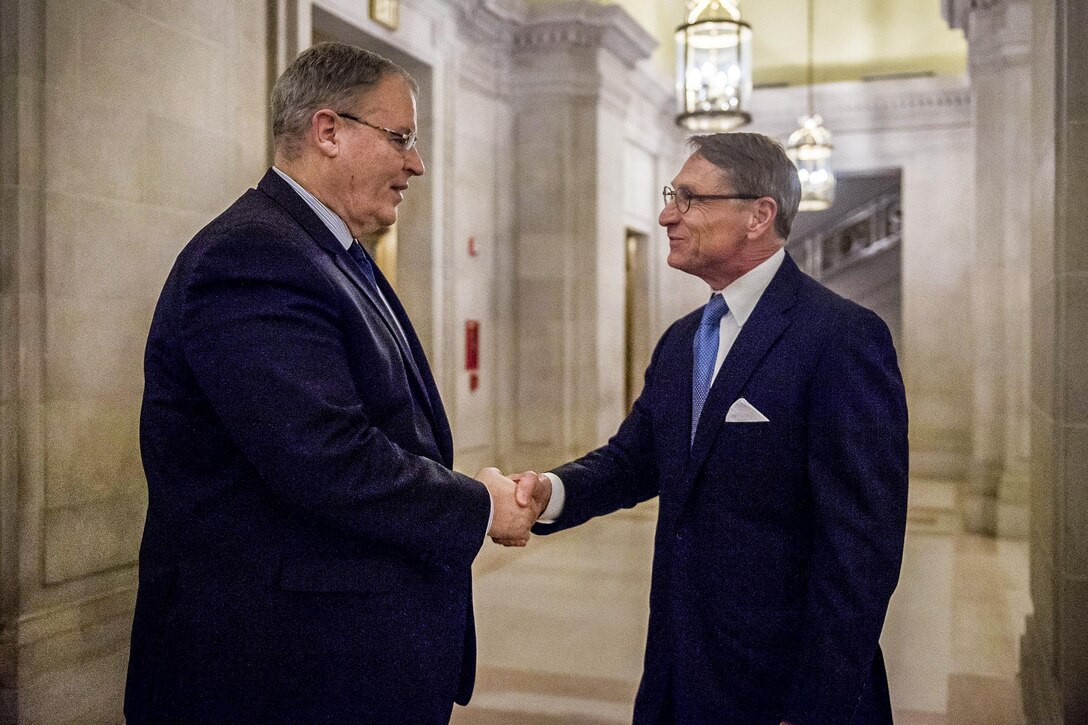 Deputy Defense Secretary Bob Work, left, shakes hands with Tom Stroup, president of the Satellite Industry Association, as Work arrives to deliver remarks at the association's leadership dinner in Washington, D.C., March 7, 2016. The annual event gathers senior government officials, CEOs and other senior executives from the satellite industry to underscore the dynamic role that satellite technologies play in the nation’s economy and defense. DoD photo by Air Force Senior Master Sgt. Adrian Cadiz