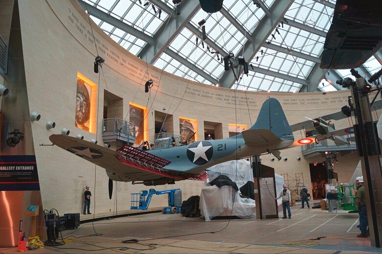 A refinished Dauntless dive bomber is put in place in the National Museum of the Marine Corps