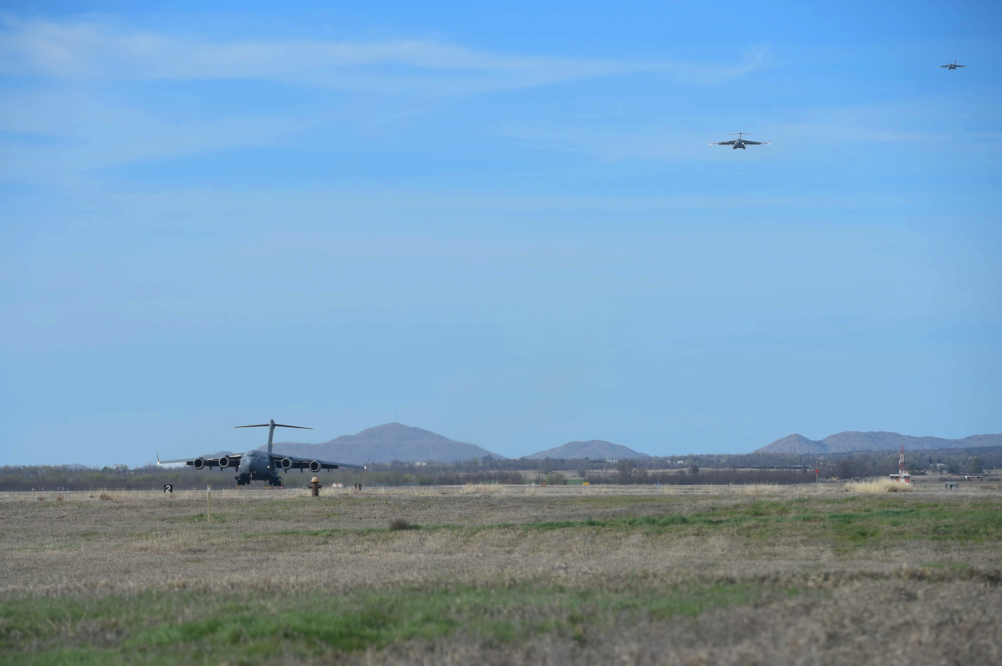 A three-ship formation of U.S. Air Force C-17 Globemaster III cargo aircraft prepare to land, March 4, 2016, on the flightline at Altus Air Force Base, Okla. Eight aircraft from Altus AFB met with four additional aircraft from Travis Air Force Base, Calif. and Joint Base Lewis-McChord, Wash. to realistically train U.S. Air Force aircrew members for future multi-base operations. (U.S. Air Force photo by Senior Airman Dillon Davis/Released)