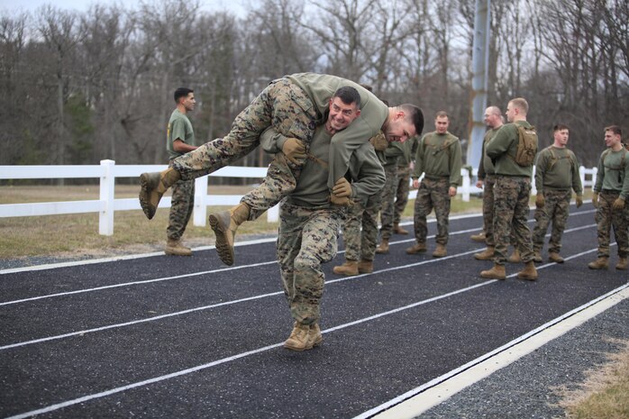 Lincoln, N.H. - Native Chief Warrant Officer 2 Kerry J. O'Connell, Decontamination Platoon Commander, Chemical Biological Incident Response Force (CBIRF), U.S. Marine Forces Command (MARFORCOM), fireman carries a Marine during a battalion-wide physical training (PT) session. CBIRF Corporals led the battalion in a PT event ranging from pushups and lunges to buddy drags and fireman carry drills the morning before their graduation from Corporals Leadership Course, Feb. 26, 2016. The noncommissioned officers completed the 3 week course curriculum that included sword and guidon manual, land navigation, Marine Corps promotion system for sergeants and below and other small unit leader skills and traits. (Official USMC Photos by Sgt. Santiago G. Colon Jr./Released)
