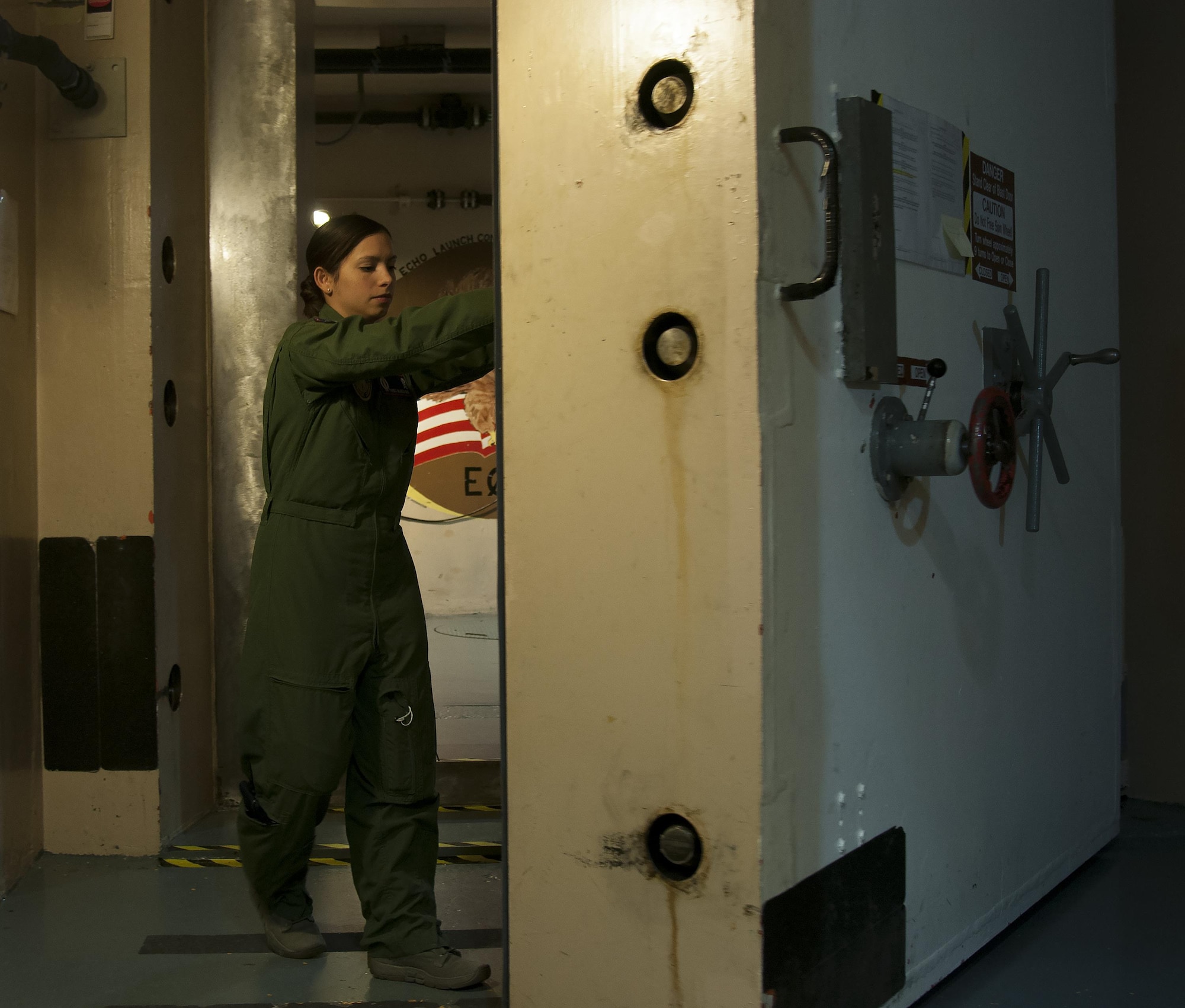 First Lt. Pamela Blanco-Coca, 319th Missile Squadron missile combat crew commander, closes the blast door underground at a Missile Alert Facility in the F.E. Warren Air Force Base, Wyo., missile complex Feb. 9, 2016. Heavy blast doors add to the survivability of the capsules and crews, in turn improving the ICBM force's deterrence capability. (U.S. Air Force photo by Senior Airman Jason Wiese)