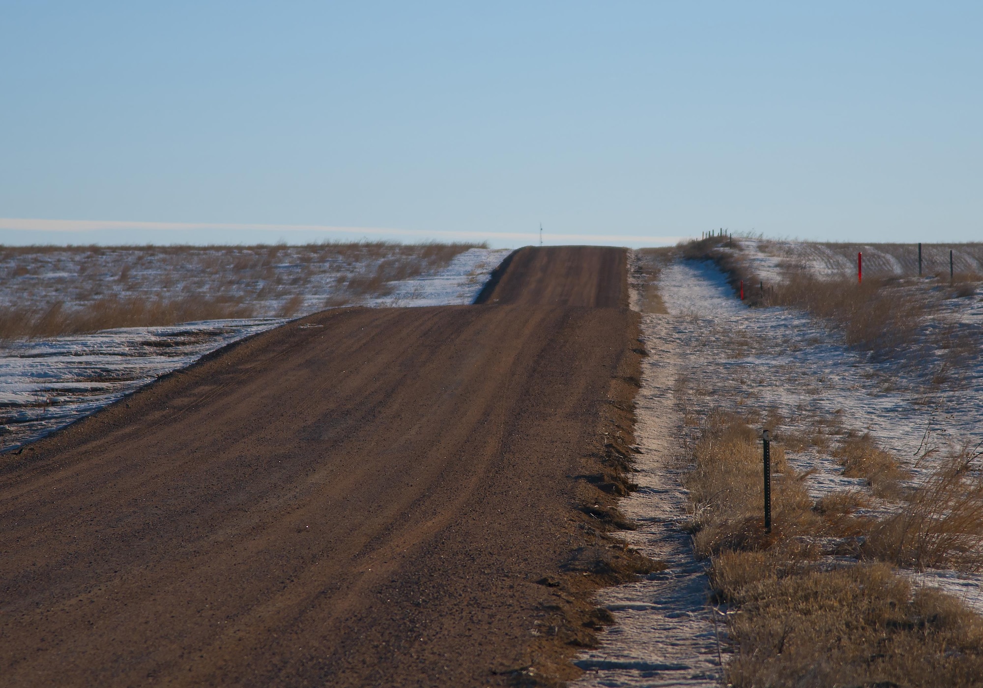 This photo depicts a hilly stretch of gravel road in the F.E. Warren Air Force Base, Wyo., missile complex. A combined total of more than 7 million miles is driven by Mighty Ninety Airmen annually. Much of the driving is done over roads like these, which can be especially hazardous in the winter, so all base personnel traveling in the missile complex receive specialized training for these conditions. (U.S. Air Force photo by Senior Airman Jason Wiese)