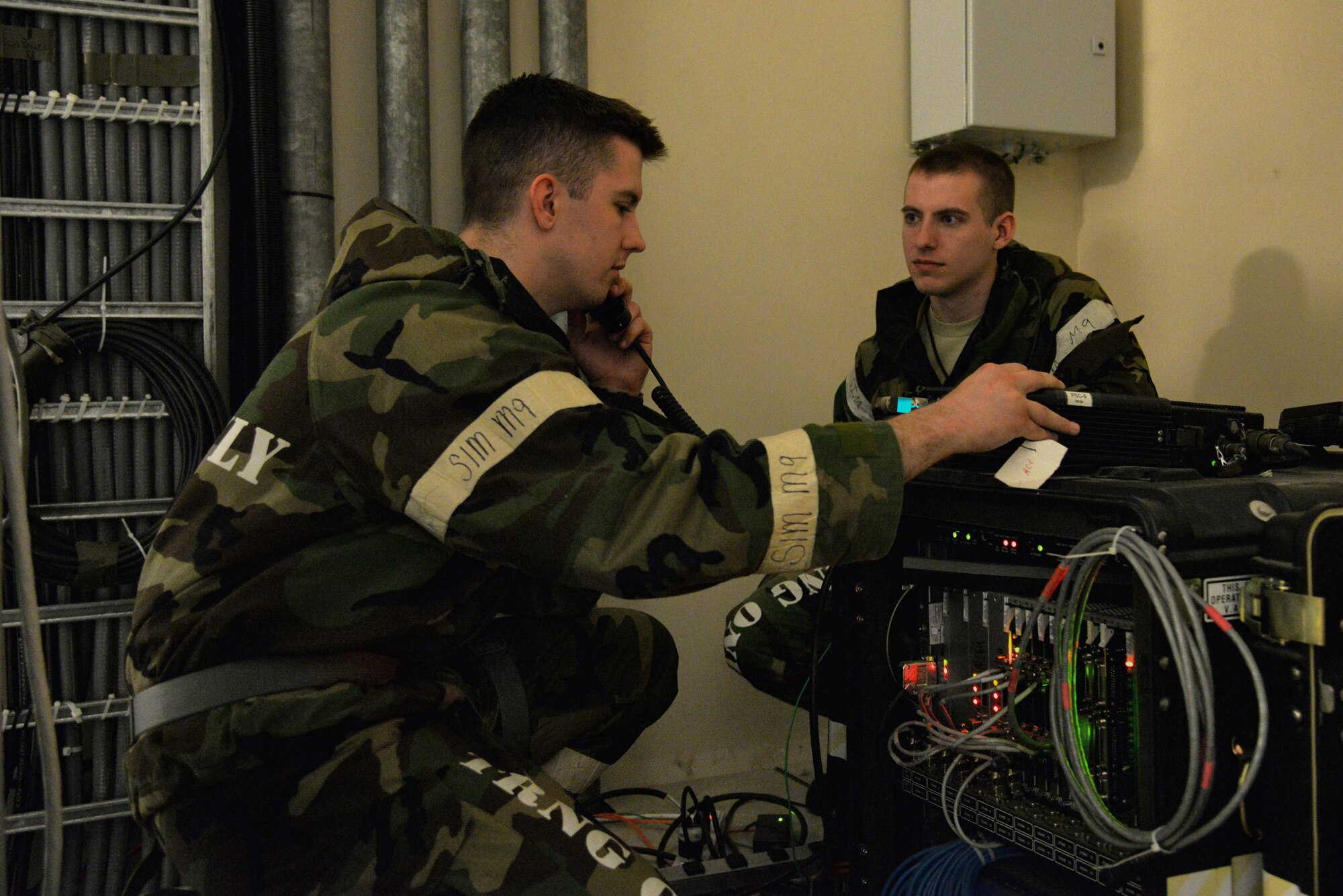 Airman 1st Class Kyle Martin, 51st Communications Squadron radio frequency transmission systems technician, conducts a radio test as Senior Airman Darian Hodges, 51st CS client systems technician, looks on during exercise Beverly Midnight 16-01 on March 8, 2016, at Osan Air Base, Republic of Korea. Martin and Hodges are part of a team of communications Airmen that support requests in the emergency operations center here during BM 16-01, an exercise designed to test the warfighting capabilities of units under the 51st Fighter Wing with a focus on readiness, defending the base and executing flying operations. (U.S. Air Force photo by Tech. Sgt. Travis Edwards/Released)