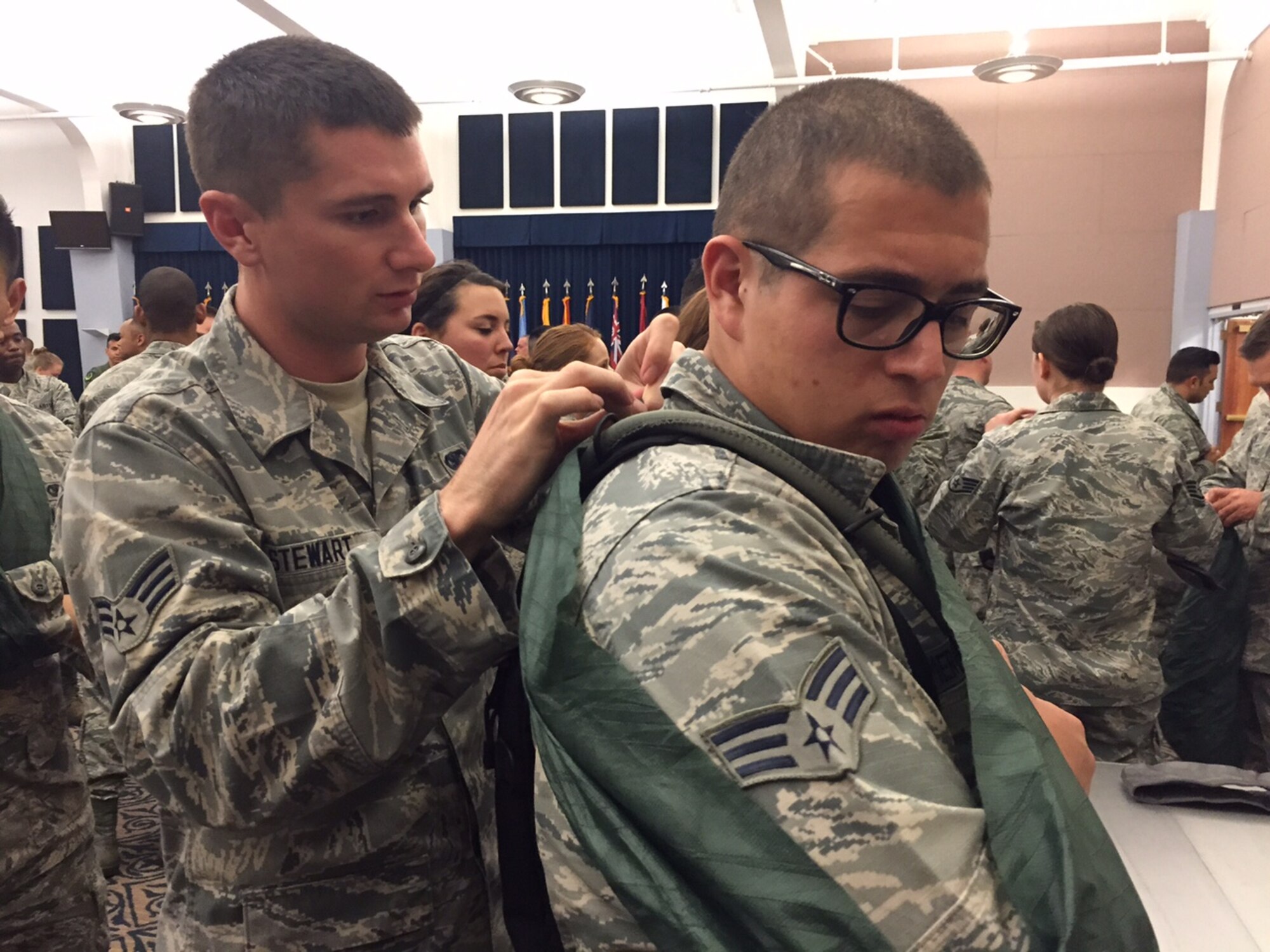 Two 940th Security Forces personnel practice first aid bandaging techniques at annual first aid training, at Beale Air Force Base, California, March 6, 2016. Senior Airman Bradley Stewart ties a knot around Senior Airman Jorge Romero’s green bandage, called a swathe. A swathe is a bandage of material of about 3-6 inches wide used for arm slings and other wounds. (U.S. Air Force photo by Tech. Sgt. Heather Skinkle)