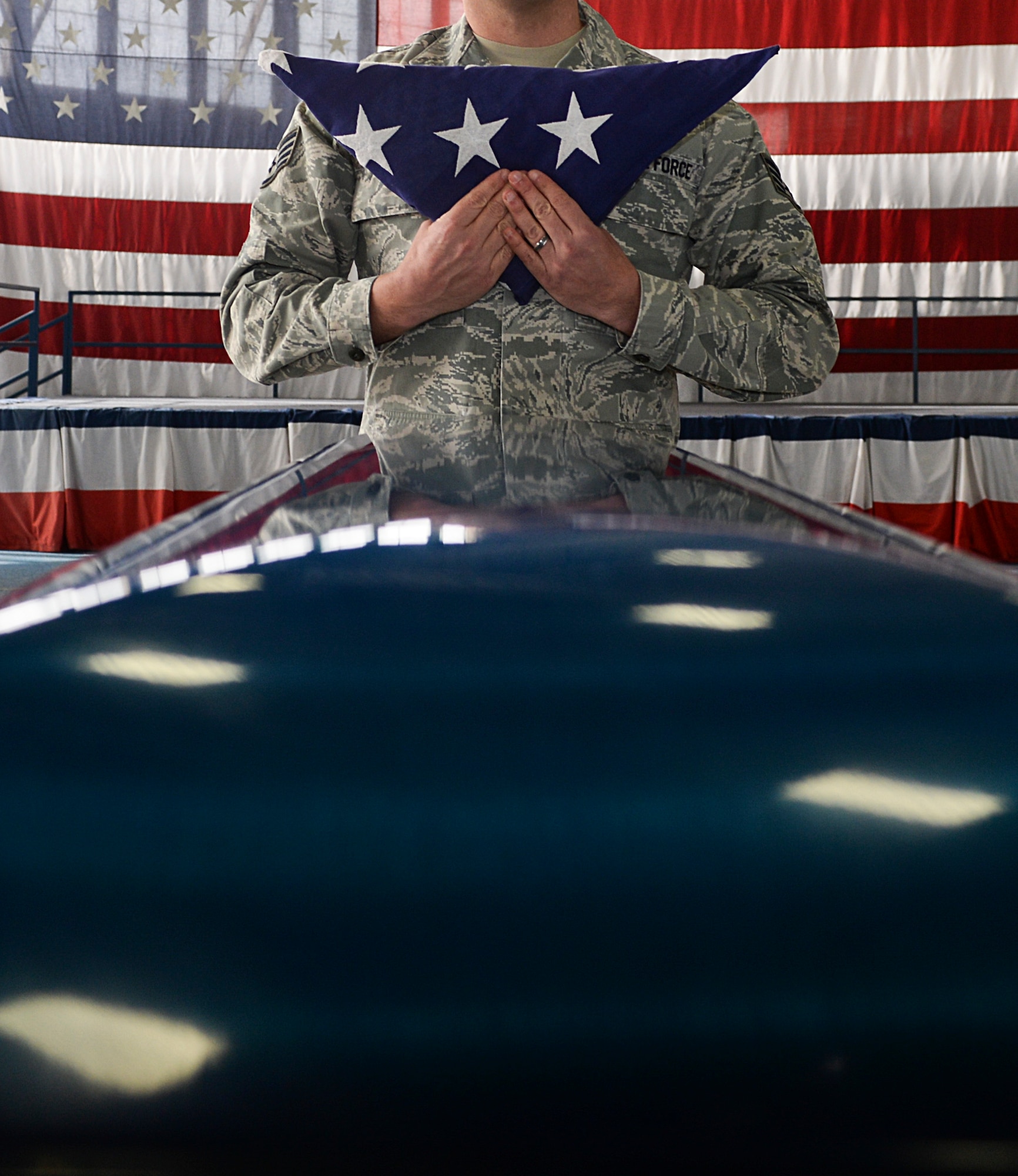 Staff Sgt. Jason Prescott, 28th Medical Support Squadron medical war reserve material NCO in charge, prepares to place a flag on a casket during Honor Guard training at Ellsworth Air Force Base, S.D., Feb. 22, 2016. Once fallen servicemembers have been brought to their duty location by a search and recovery team, Honor Guardsmen pay their respects by holding a ceremony. (U.S. Air Force photo by Airman Sadie Colbert/Released)