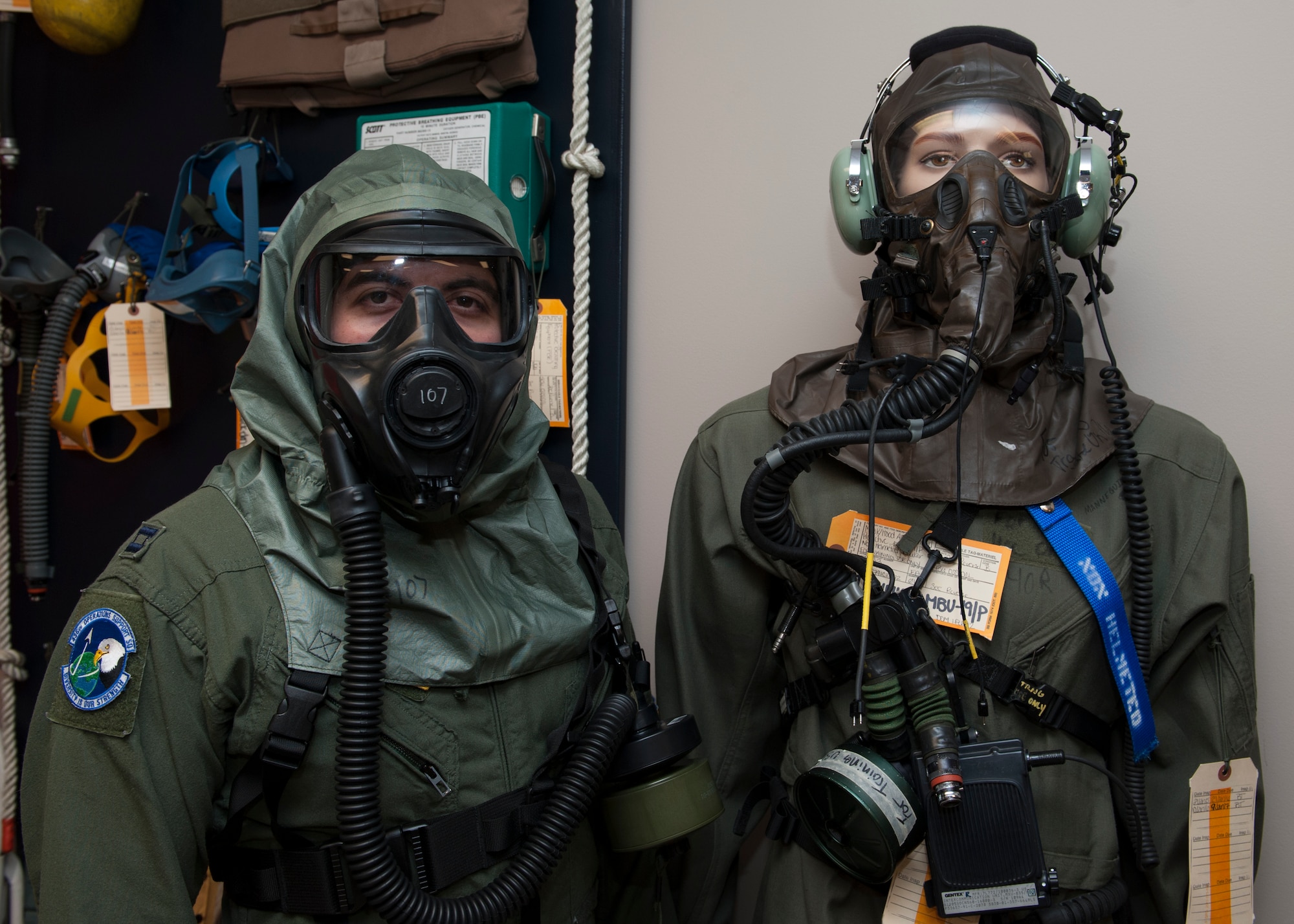 Capt. Edward Silva, 436th Operations Support Squadron Aircrew Flight Equipment commander, poses while wearing the XM69 Aircrew Chemical, Biological, Radiological and Nuclear Defense (CBRN) system while standing next to a mannequin wearing the legacy U.S. Air Force Aircrew Eye Respiratory Protection (AERP) system March 2, 2016, inside the Aircrew Flight Equipment facility on Dover Air Force Base, Del. These masks are worn by aircrew members in the event they are exposed to a chemical, biological, radiological or nuclear environment. (U.S. Air Force photo/Senior Airman Zachary Cacicia)