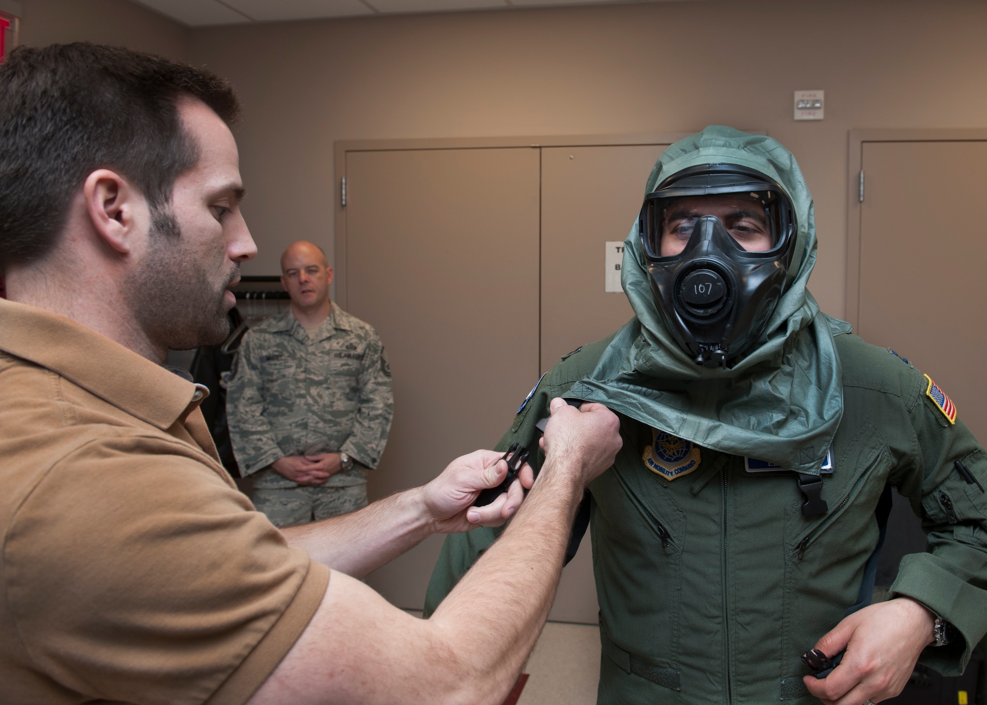 Capt. Edward Silva, 436th Operations Support Squadron Aircrew Flight Equipment commander, puts on the XM69 Aircrew Chemical, Biological, Radiological and Nuclear Defense (CBRN) system and is assisted by Steve Leadore, Joint Service Aircrew Strategic Program team test analyst, March 2, 2016, inside the Aircrew Flight Equipment facility on Dover Air Force Base, Del. The Air Force, Army, Navy and Marine Corps all utilize their own unique aircrew CBRN system. The XM69 is being developed as a single system that will be utilized by all four branches. (U.S. Air Force photo/Senior Airman Zachary Cacicia)