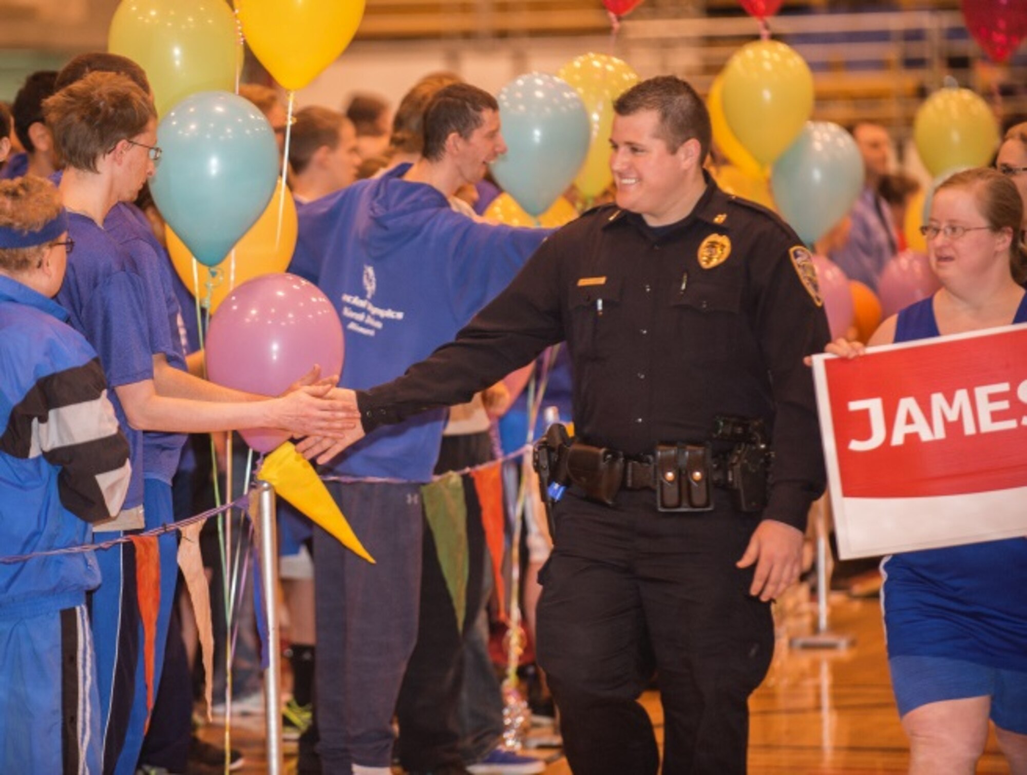 A member of the Minot Police Department high-fives participants in the North Dakota Special Olympics in Minot, N.D., March 4, 2016. Many members of the Minot community showed their support at the event. (U.S. Air Force photo/Airman 1st Class Christian Sullivan)