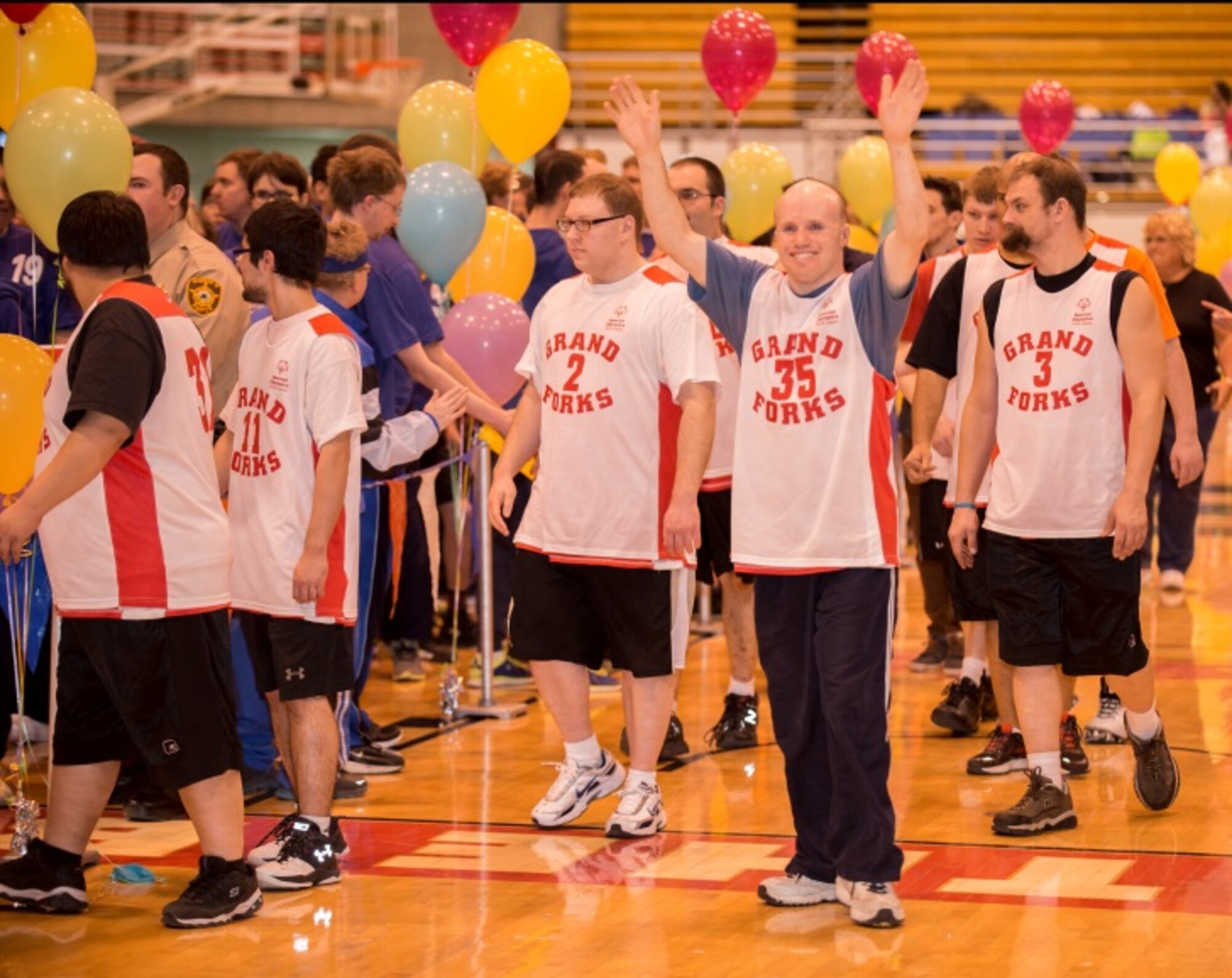 A member of the Grand Forks Special Olympics team waves to the crowd as his team is introduced at the North Dakota Special Olympics in Minot, N.D., March 4, 2016. Minot Air Force Base members volunteered at the event as referees and other volunteer positions. (U.S. Air Force photo/Airman 1st Class Christian Sullivan)
