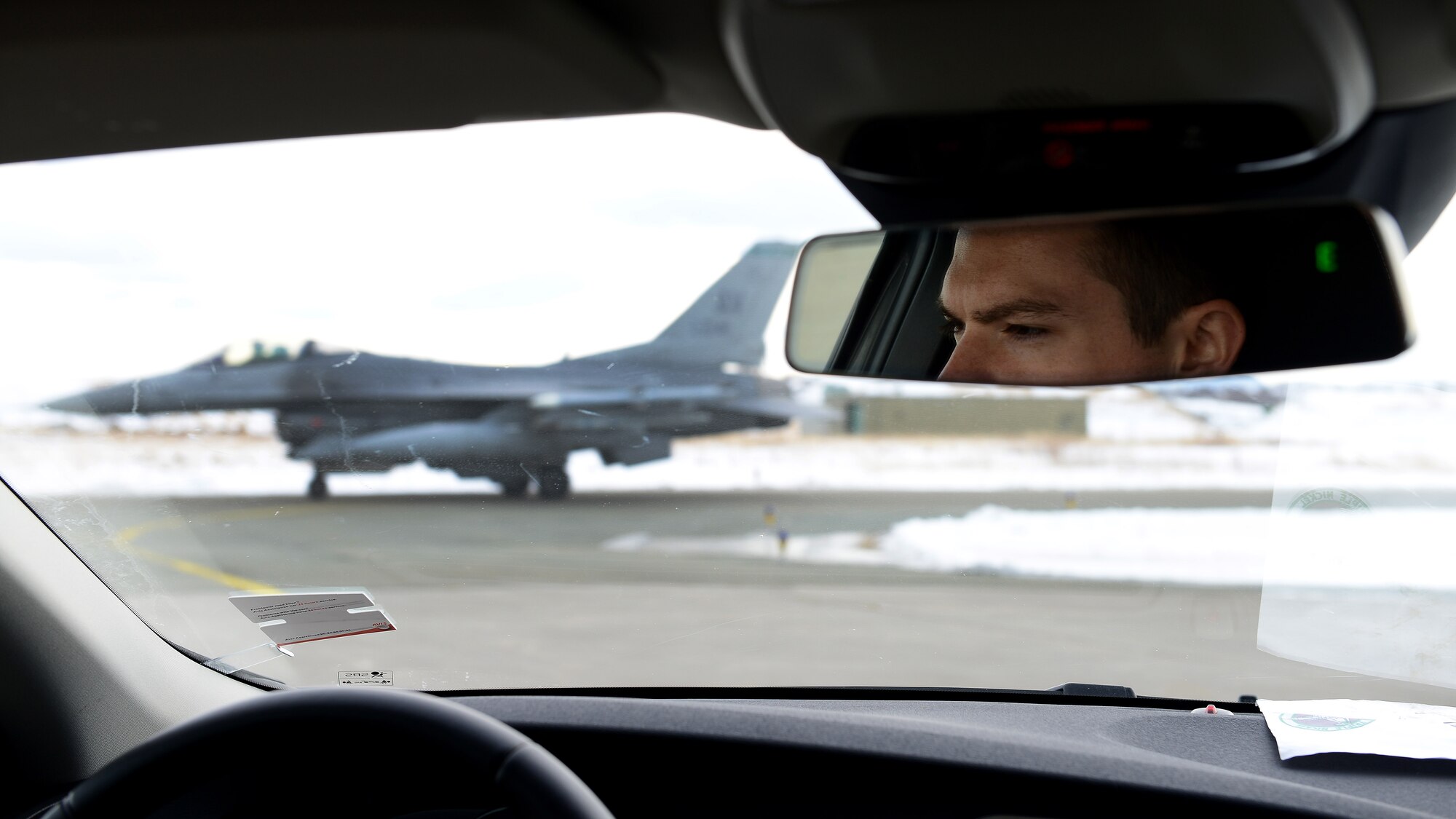 Senior Airman Tyler Caires, 31st Security Forces Squadron security response team member, watches an F-16 Fighting Falcon travel across the taxiway, March 5, 2016, at Bodø Main Air Station, Norway. Six F-16s, approximately 150 Airmen and more than 105 tons of cargo arrived at Bodø from Aviano Air Base, Italy, for Exercise Cold Response 16. (U.S. Air Force photo by Tech. Sgt. R.J. Biermann/Released)