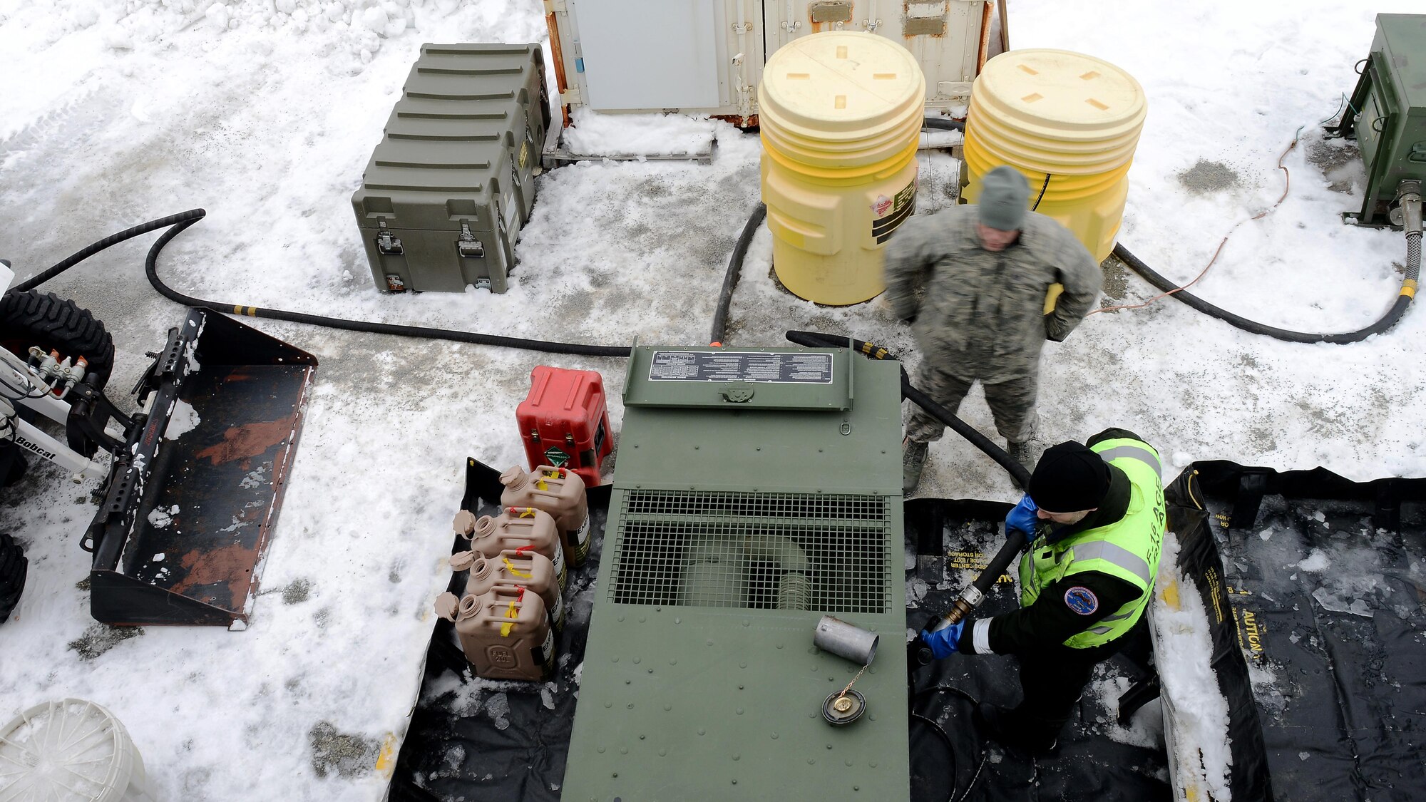 Norwegian air force Capt. Bgørnare Stensland, 132nd Air Wing air ground equipment technician refuels a generator while U.S. Air Force Tech. Sgt. Joshua Dow, 265th Combat Communications Squadron power production technician, looks on at Bodø Main Air Station, Norway, March 2, 2016. The Norwegian, U.S. and Belgian air forces partnered to support the exercise. (U.S. Air Force photo by Tech. Sgt. R.J. Biermann/Released)