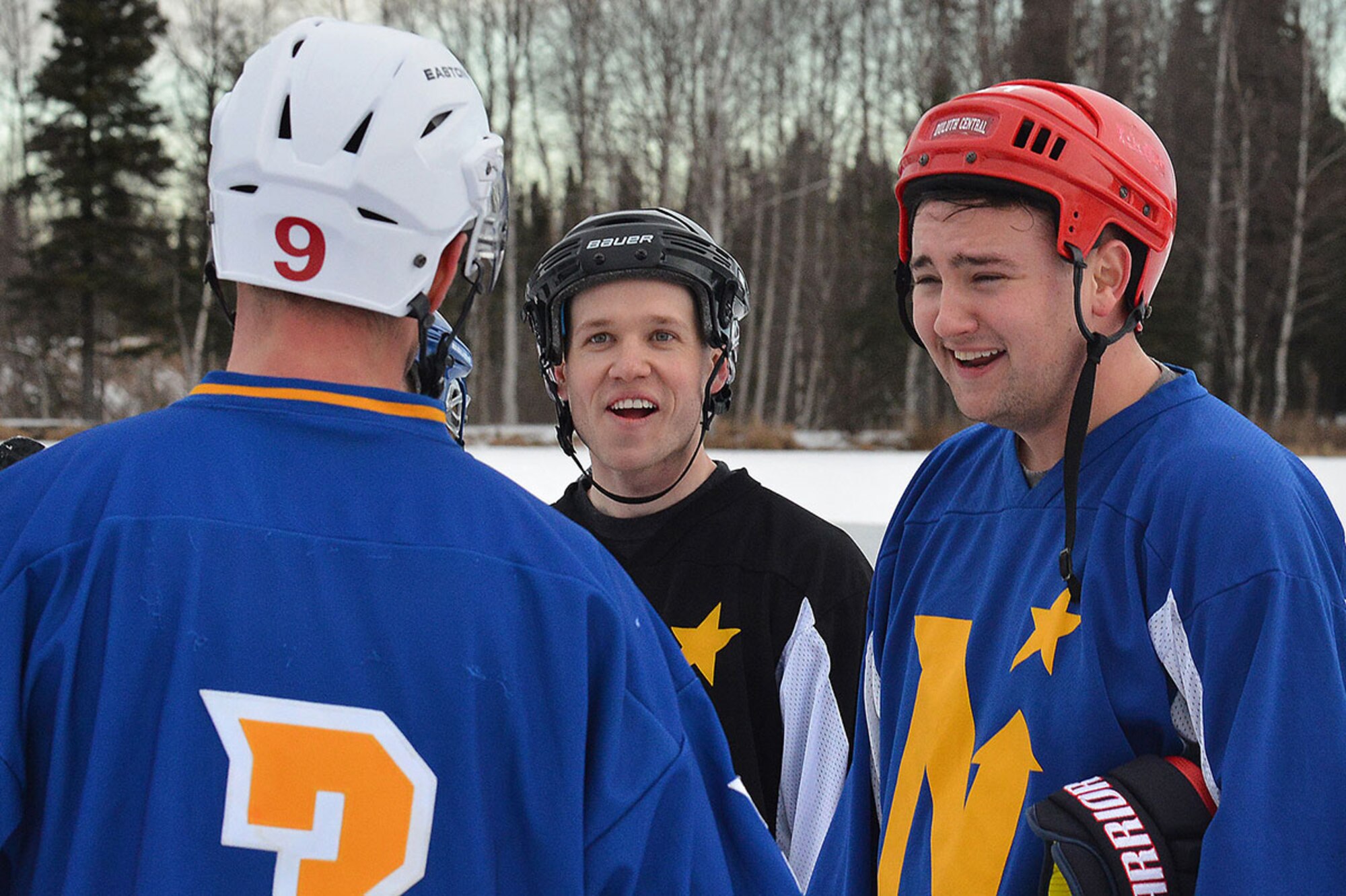 Senior Airman Joe Dumancas, a dental laboratory technician with the 673d Dental Squadron (right) and Airman 1st Class Robin Knight, a cargo specialist with the 773rd Logistics Readiness Squadron, (center) laugh as they take a break in between matches at The Last Frontier Pond Hockey Classic hosted in Anchorage, Alaska March 5. The tournament was held as part of the Fur Rendezvous festivities, and featured eight separate divisions, each with multiple groups of teams competing to be the best in their respective division. (U.S. Air Force photo by Airman 1st Class Kyle Johnson)