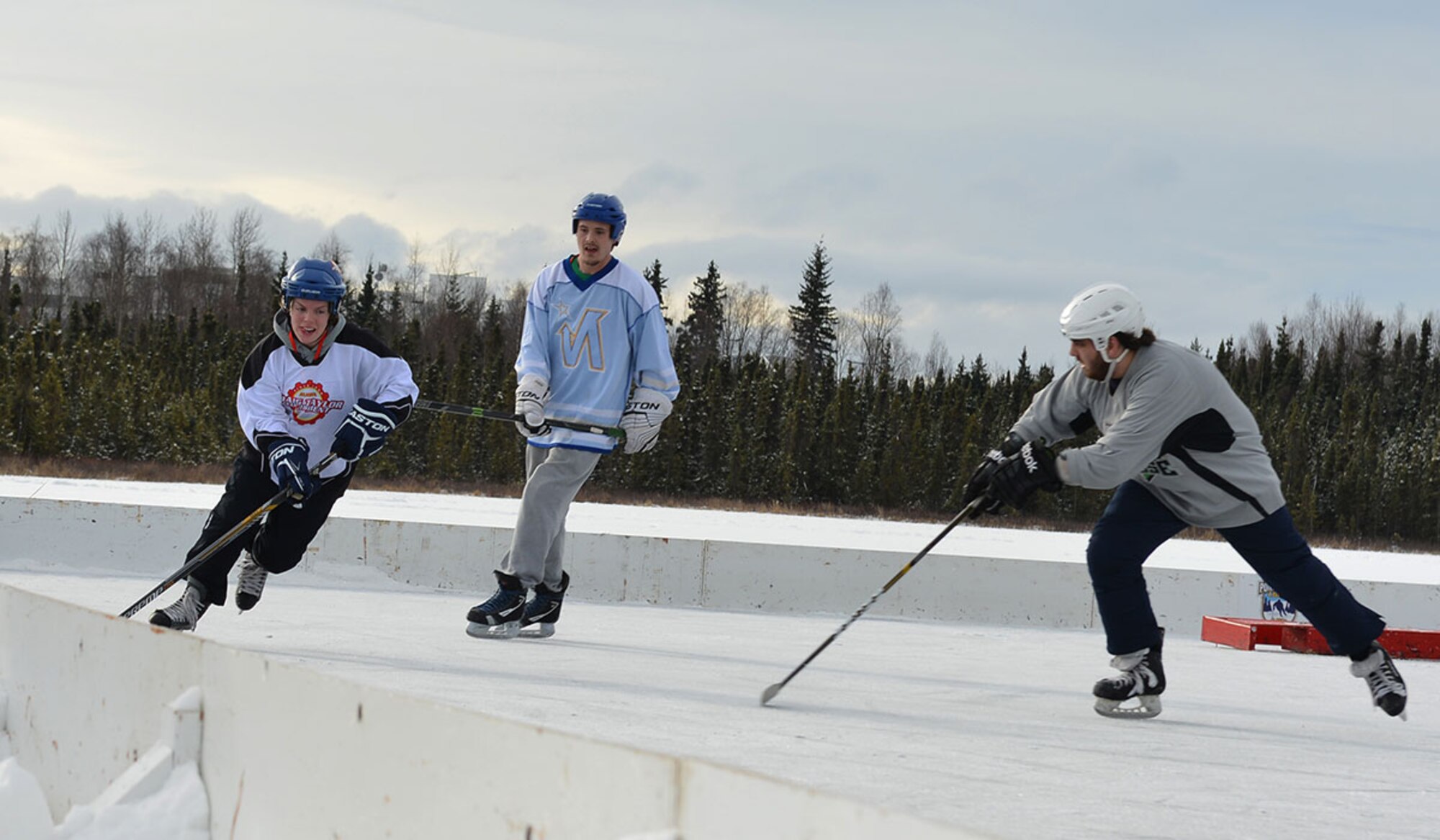 Senior Airman Therese Holm, (left) a mental health technician with the 673d Mental Operations Squadron, skates the puck past an opposing player in her team’s third match at The Last Frontier Pond Hockey Classic hosted in Anchorage, Alaska March 5. The tournament was held as part of the Fur Rendezvous festivities, and featured eight separate divisions, each with multiple groups of teams competing to be the best in their respective division. (U.S. Air Force photo by Airman 1st Class Kyle Johnson)