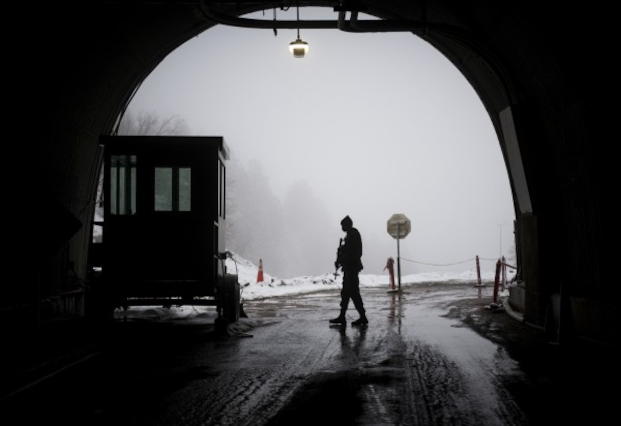 CHEYENNE MOUNTAIN AIR FORCE STATION, Colo. - Senior Airman Ricardo Collie, a 721st Security Forces member, patrols the north gate of the Cheyenne Mountain Complex at Cheyenne Air Force Station, Colorado. Collie is one of many security layers to enter more than a mile inside a Colorado mountain to a complex of steel buildings that sit in caves. (Photo by Staff Sgt. Andrew Lee )
