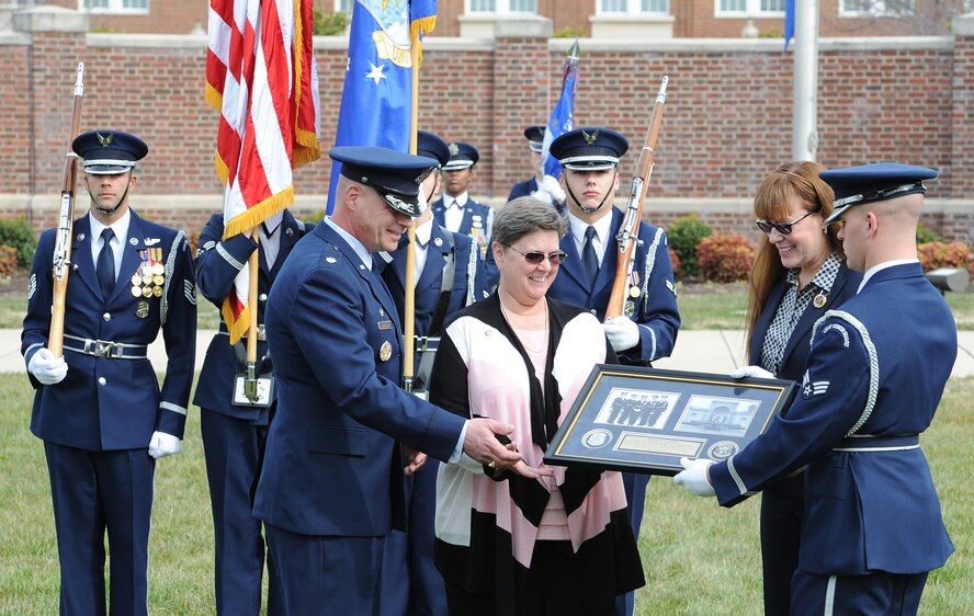 United States Air Force Honor Guard Commander Lt. Col. Peter Tritsch and Lt. Col. (ret.) Betsy Adams honor Master Sgt. (ret.) Margaret Jones with a plaque during a ceremony to recognize four of the first five female enlisted ceremonial guardsmen at Joint Base Anacostia-Bolling, Mar. 8. The event included a formal lawn ceremony, a ribbon-cutting to christen a display case honoring the first women to join the Air Force Honor Guard, and a panel discussion. (U.S. Air Force photo/Jim Lotz)