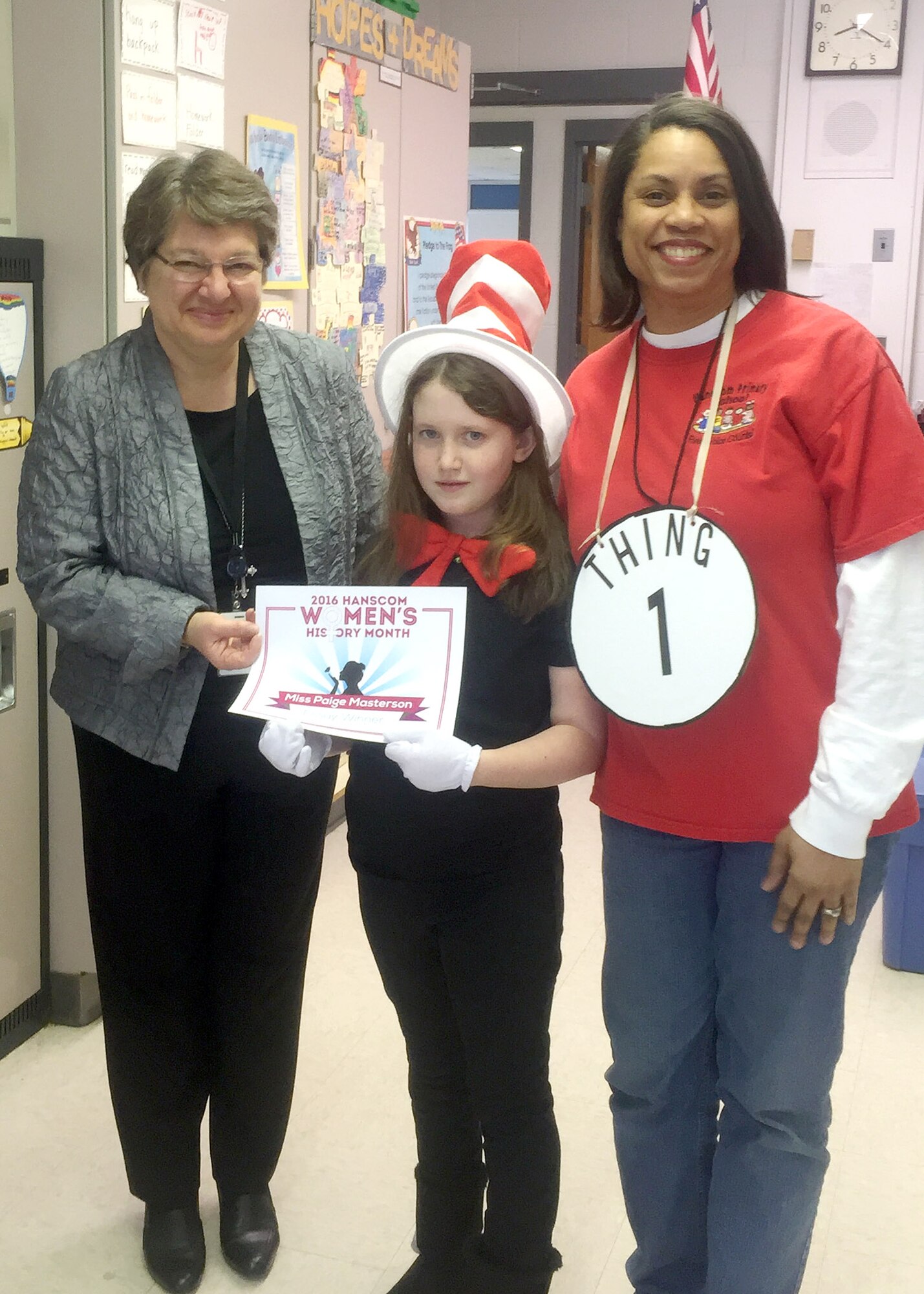 Hanscom Primary School third grader, Paige Masterson, receives a certificate from Tanya Lambert, left, Women's History Month committee member, and Julie Johnson, HPS teacher, earlier this week at the school. The WHM committee and primary school teamed up on an essay contest that reflected this year’s WHM theme, 'Honoring Women in Public Service.' Masterson won for her essay on Eleanor Roosevelt. (Courtesy photo)