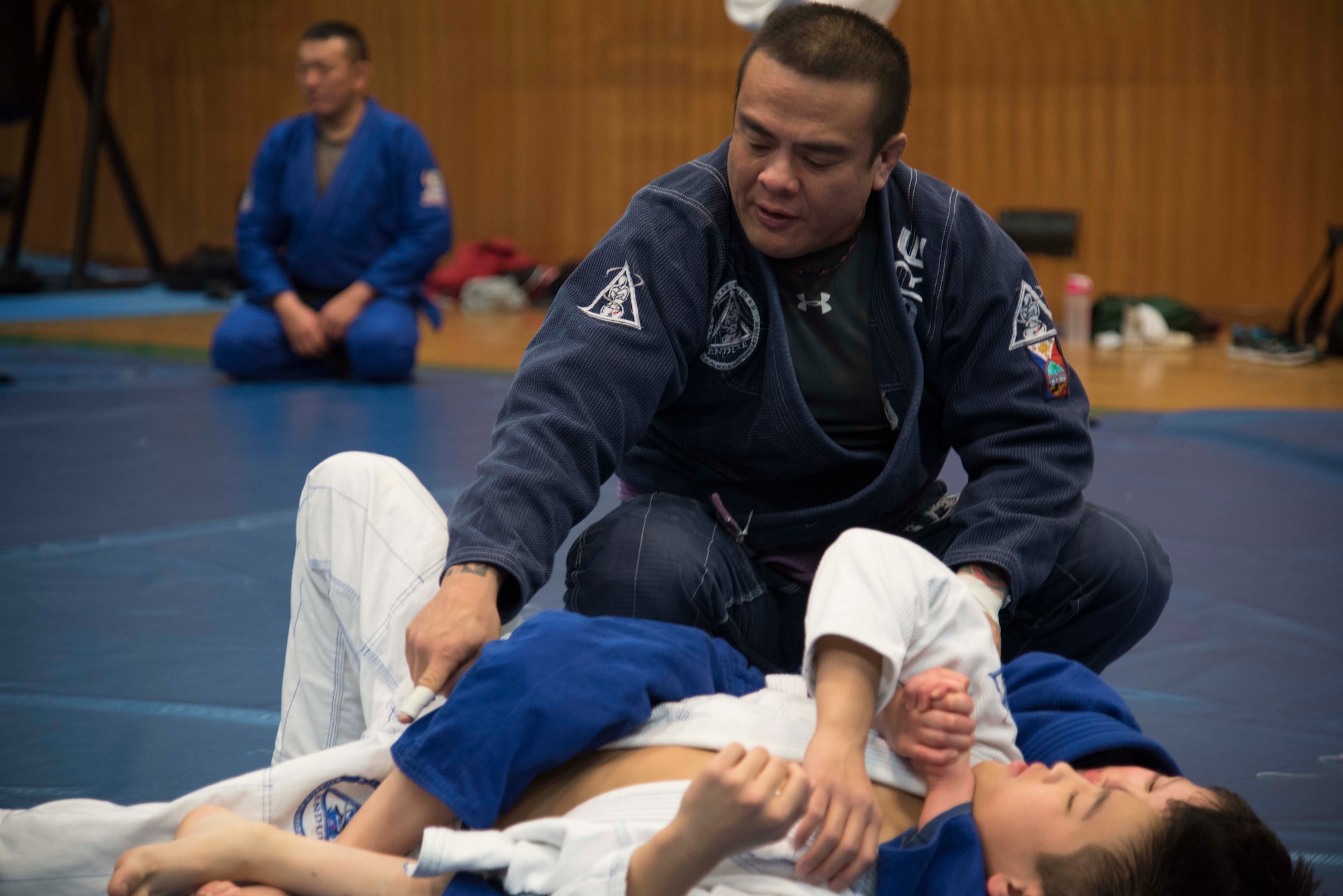 Rodrigo Gomez, the head coach of Endure Brazilian jiu-jitsu Misawa, teaches jiu-jitsu members how to perform a technique at Misawa Air Base, Japan, Feb. 17, 2016. The instructor will watch pairs perform specific sparring moves and then correct or give them advice when needed. (U.S. Air Force photo by Airman 1st Class Jordyn Fetter)