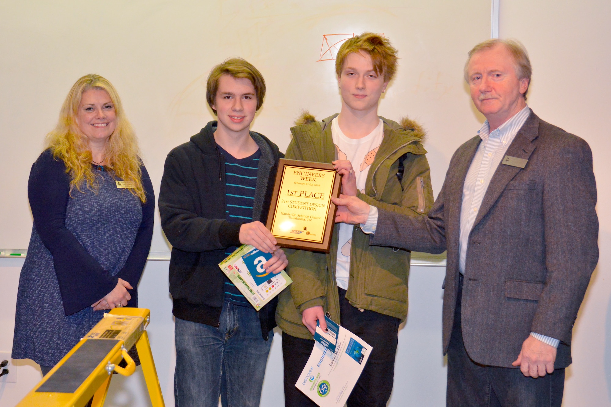 Jamie Treadwell (left), Hands on Science Center education director, and Dr. Patrick Murphy (far right), Hands on Science Center executive director, present the Student Design Competition first prize to John Farris (second from left) and Daniel McNair with St. Andrews-Sewanee School. The competition, held Feb. 22 at the Hands on Science Center in Tullahoma, was a challenge presented to 31 student teams where they had to design and build a bridge large enough to support a mass exodus for a city using provided materials. (Courtesy photo)