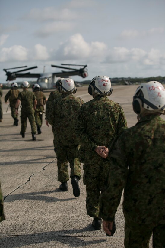 Members of the Japan Ground Self-Defense Force are escorted to a MV-22B Osprey to experience a firsthand demonstration of its capabilities at Marine Corps Air Station Futenma, Okinawa, Japan, March 8, 2016. Opportunities to showcase military abilities provide an avenue to increase relations and interoperability in the Asia-Pacific region. The Osprey is with Marine Medium Tiltrotor Squadron 262, Marine Aircraft Group 36, 1st Marine Aircraft Wing, III Marine Expeditionary Force. (U.S. Marine Corps photo by Cpl. William Hester/ Released)