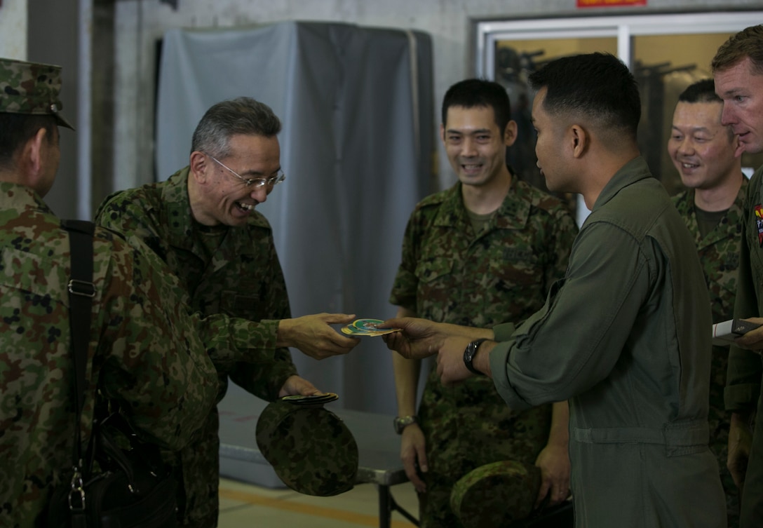 Maj. Gen. Hideki Agario exchanges gifts with U.S. Marines after being on a demonstration flight during a visit to Marine Corps Air Station Futenma, Okinawa, Japan, March 8, 2016. Agario and fellow service members visited MCAS Futenma to observe and experience the MV-22B Osprey’s maneuverability and payload capabilities while increasing relations between allied nations in the Asia-Pacific region. Agario is the commanding general of the 15th Brigade, Japan Ground Self-Defense Force, located in Naha, Okinawa. The Marine are with Marine Medium Tiltrotor Squadron 262, Marine Aircraft Group 36, 1st Marine Aircraft Wing, III Marine Expeditionary Force. (U.S. Marine Corps photo by Cpl. William Hester/ Released)