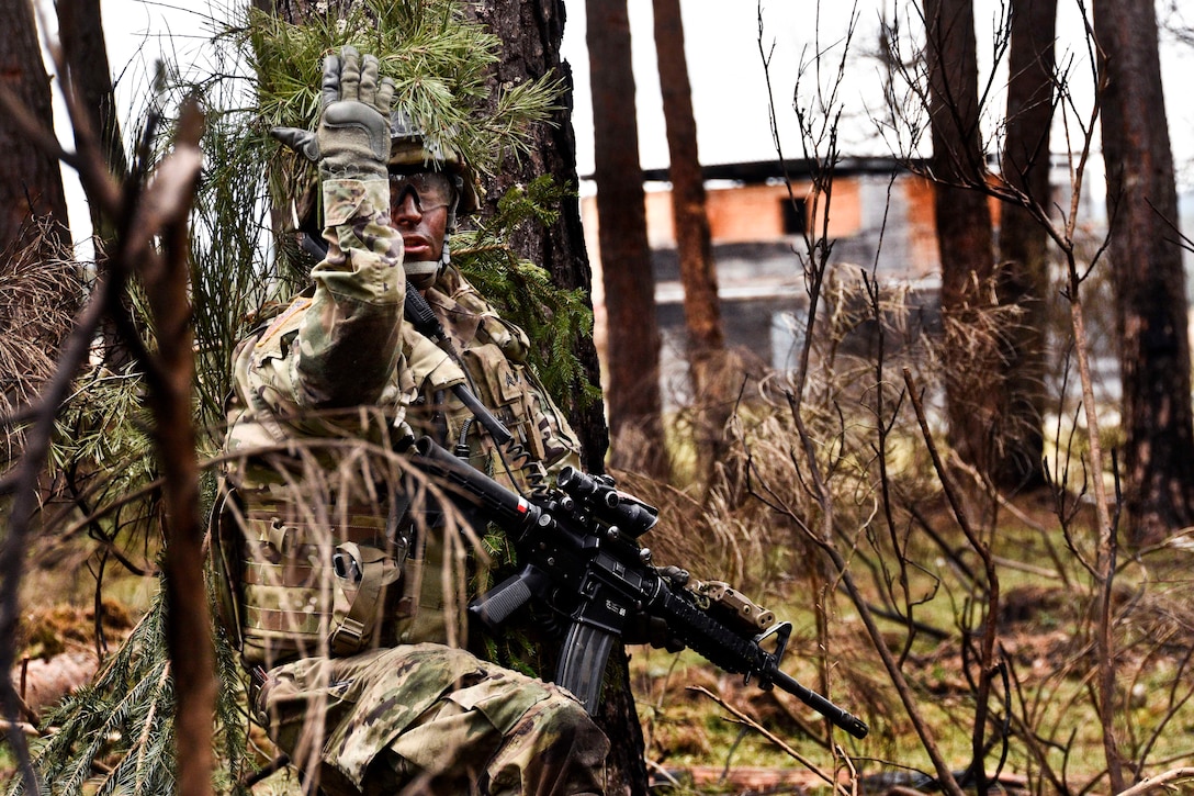 Army Sgt. Daniel Mukavetz signals for his team to move up during a live-fire exercise at Grafenwoehr Training Area, Germany, Feb. 24, 2016. Mukavetz is a cavalry scout assigned to the 4th Squadron, 2nd Cavalry Regiment. Army photo by Sgt. William A. Tanner
