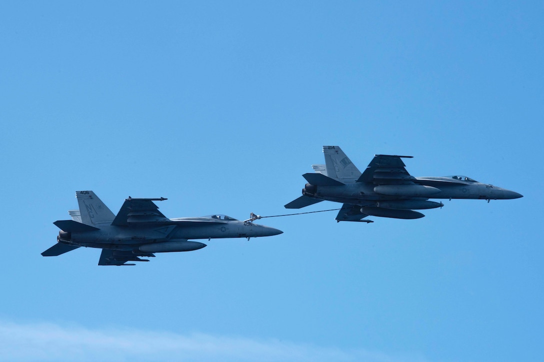 Two F/A-18E Super Hornets assigned to the Vigilantes of Strike Fighter Squadron 151 and the Tophatters of Strike Fighter Squadron 14 perform an aerial refueling operation during an airpower demonstration over the aircraft carrier USS John C. Stennis in the Philippine Sea, March 7, 2016. Navy photo by Petty Officer 3rd Class Kenneth Rodriguez Santiago