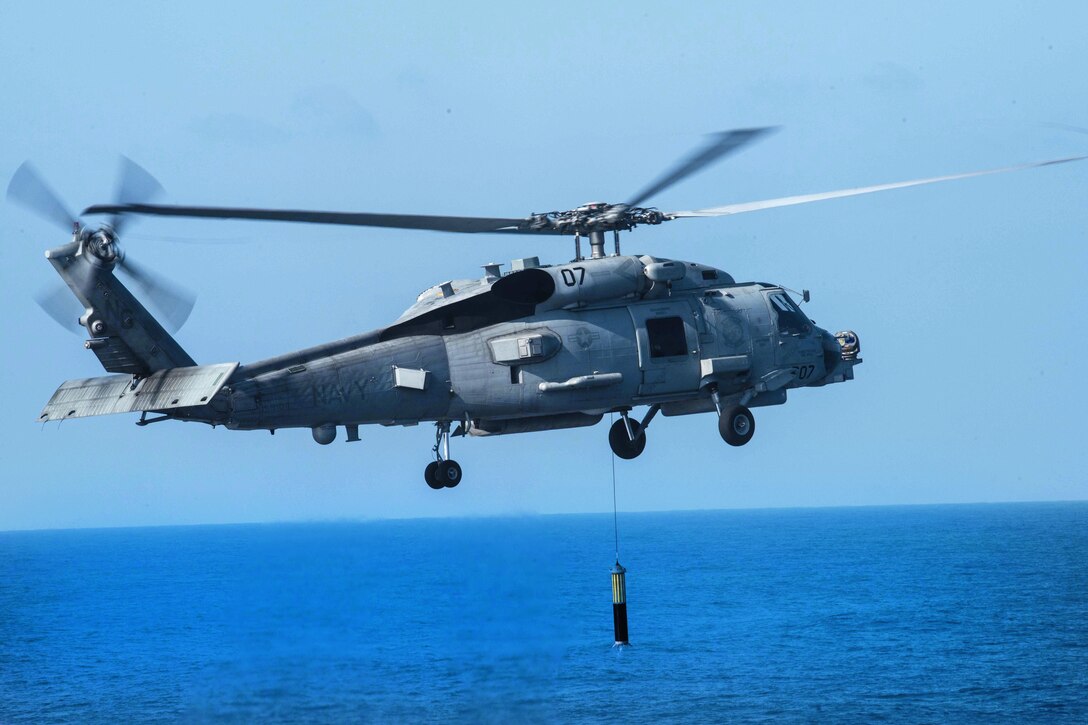 An MH-60R Sea Hawk helicopter assigned to the Raptors of Helicopter Maritime Strike Squadron 71 lowers sonar equipment into the water next to the aircraft carrier USS John C. Stennis during an airpower demonstration in the Philippine Sea, March 7, 2016. Navy photo by Petty Officer 3rd Class Kenneth Rodriguez Santiago