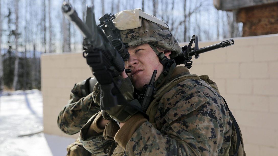 U.S. Marine Corps Cpl. Joseph Myers, assigned to Detachment Military Police Company D, 4th Law Enforcement Battalion, holds a security position while assaulting Baumeister City military operations on urban terrain complex at Joint Base Elmendorf-Richardson, Alaska, March 6, 2016. The MOUT training prepared the Marines for their upcoming deployment to Serbia where they will serve as military police advisors. (U.S. Air Force photo/Alejandro Pena)
