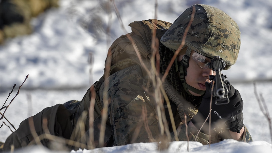 U.S. Marine Corps Cpl. Deion Delara, assigned to Detachment Military Police Company D, 4th Law Enforcement Battalion, watches his sector during a convoy security halt at Joint Base Elmendorf-Richardson, Alaska, March 6, 2016. The Marines conducted military operations on urban terrain training in preparation for their upcoming deployment to Serbia where they will serve as military police advisors. (U.S. Air Force photo/Alejandro Pena)