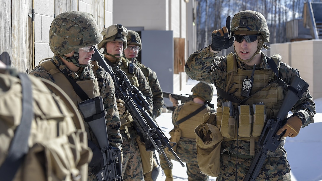 U.S. Marine Corps Cpl. William Worthy, right, assigned to Detachment Military Police Company D, 4th Law Enforcement Battalion, directs his squad while clearing a complex during military operations on urban terrain training at Joint Base Elmendorf-Richardson, Alaska, March 6, 2016. The MOUT training prepared the Marines for their upcoming deployment to Serbia where they will serve as military police advisors. (U.S. Air Force photo/Alejandro Pena)