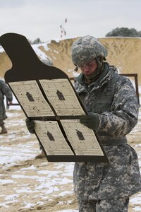 A U.S. Army Reserve soldier within the 200th Military Police Command examines his target after shooting his assigned weapon during a qualification range at Joint Base McGuire-Dix-Lakehurst March 4. (U.S. Army photo by Sgt. Jennifer Spiker)