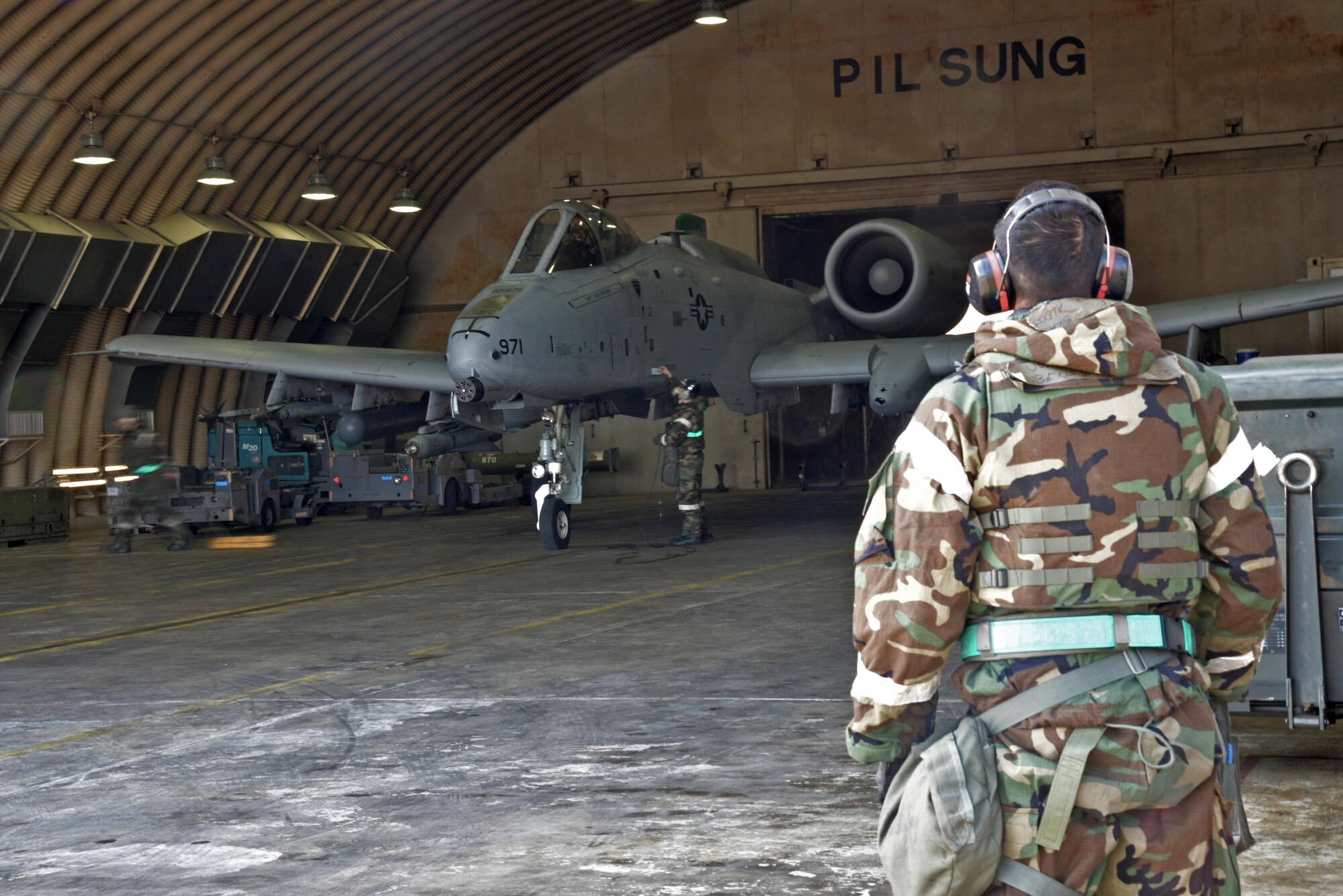 Senior Airman Alexis Benitez, 25th Aircraft Maintenance Unit crew chief, prepares to marshal an A-10 Thunderbolt II during exercise Beverly Midnight 16-01 at Osan Air Base, Republic of Korea, March 9, 2016. The jet was part of the first series of A-10s to take off during BM 16-01, an exercise designed to test the warfighting capabilities of the units assigned to the 51st Fighter Wing with a focus on readiness, defending the base and executing flying operations.  (U.S. Air Force photo by Tech. Sgt. Travis Edwards/Released)