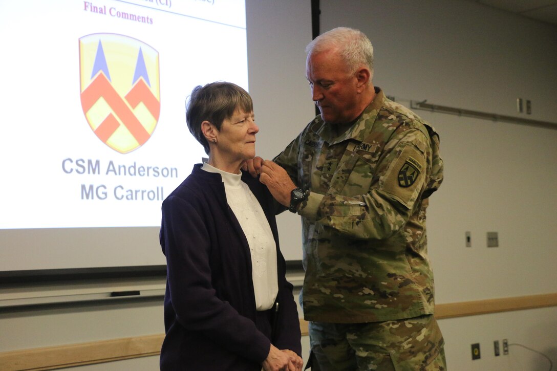 Maj. Gen. Leslie Carroll (right), the commanding general for the 377th Theater Sustainment Command presents a length of service certificate and emblem to Margaret “Peggy” Ranschaert in honor of her 45-year career of service as an Army civilian employee  during a length of service ceremony held March 4 at the Spc. Luke P. Frist Army Reserve Center at Fort Benjamin Harrison, Ind.
