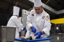 U.S. Army Reserve Culinary Arts Team member Staff Sgt. Joseph Parker, with the 451st Quartermaster Company, 143rd Sustainment Command (Expeditionary), fillets a trout during the Nutritional Hot Food Challenge category at the 41st Annual Military Culinary Arts Competitive Training Event, March 8, 2016, at Fort Lee, Va. Parker and Barnhill earned a silver in the category with their roasted beet salad, pan-seared trout, and eggless, milkless spice cake, all coming in at under 850 calories. (U.S. Army photo by Timothy L. Hale) (Released)