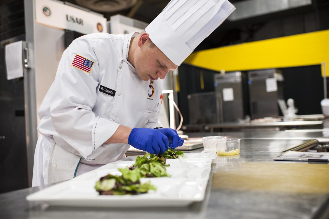 U.S. Army Reserve Culinary Arts Team member, Sgt. Joshua Barnhill, with the 377th Theater Sustainment Command, puts the finishing touches on a salad during the Nutritional Hot Food Challenge category at the 41st Annual Military Culinary Arts Competitive Training Event, March 8, 2016, at Fort Lee, Va. Parker and Barnhill earned a silver in the category with their roasted beet salad, pan-seared trout, and eggless, milkless spice cake, all coming in at under 850 calories. (U.S. Army photo by Timothy L. Hale) (Released)