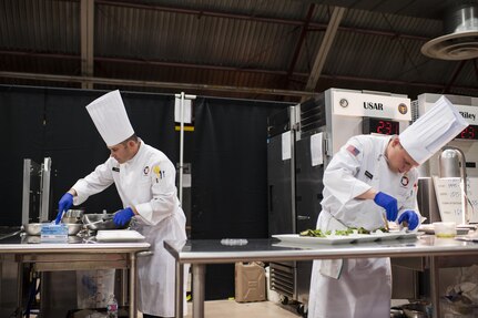 U.S. Army Reserve Culinary Arts Team members, Staff Sgt. Joseph Parker, left, with the 451st Quartermaster Company, 143rd Sustainment Command (Expeditionary), and Sgt. Joshua Barnhill with the 377th Theater Sustainment Command, plate up their entry during the Nutritional Hot Food Challenge category at the 41st Annual Military Culinary Arts Competitive Training Event, March 8, 2016, at Fort Lee, Va. Parker and Barnhill earned a silver in the category with their roasted beet salad, pan-seared trout, and eggless, milkless spice cake, all coming in at under 850 calories. (U.S. Army photo by Timothy L. Hale) (Released)